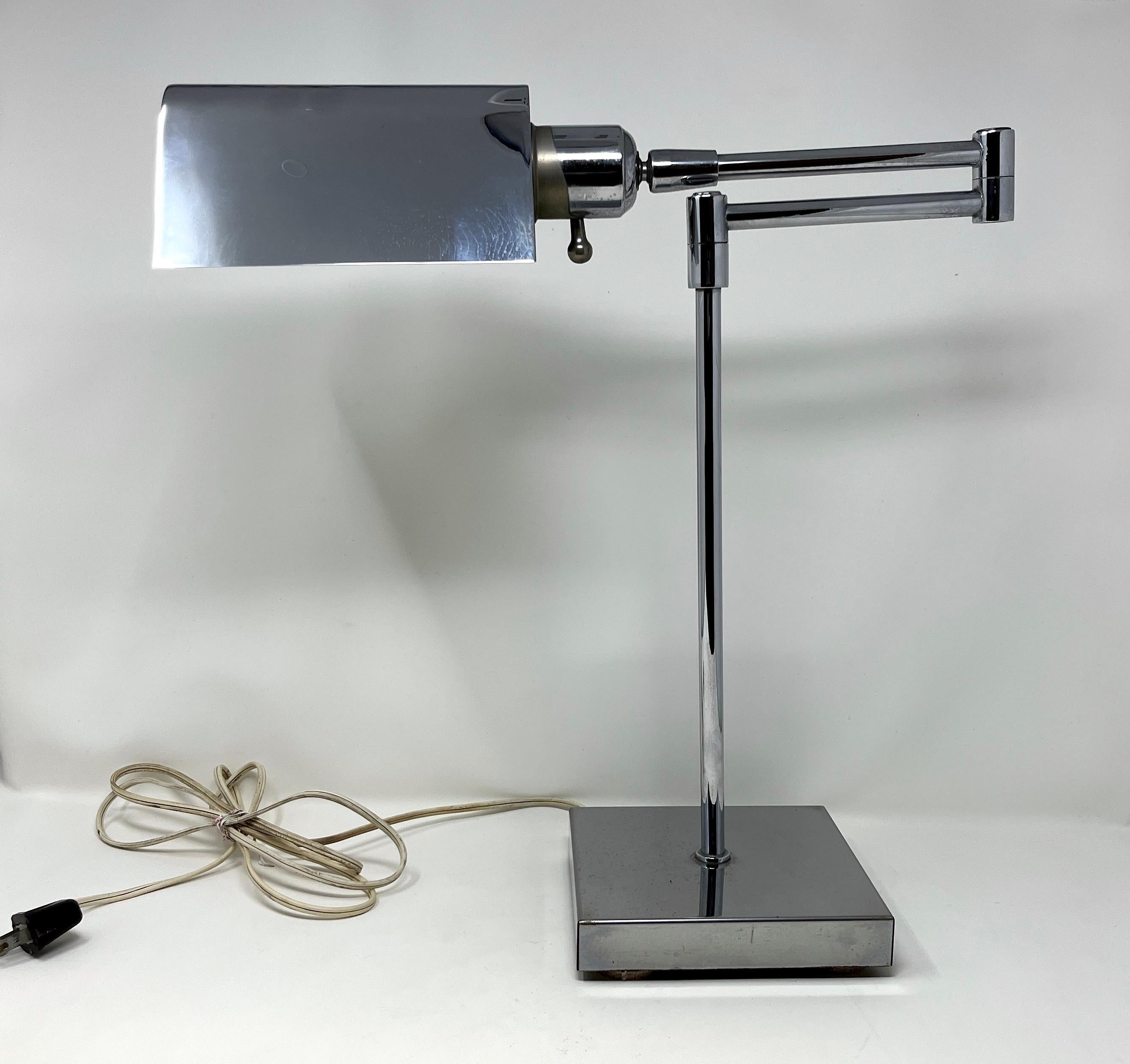 An elegant midcentury desk lamp in polished chrome in the style of Koch & Lowy; the tent shade articulates on a ball and socket and further adjusts on a swing-arm.

Lovely true vintage piece. No markings except the patent in the swivel joint which