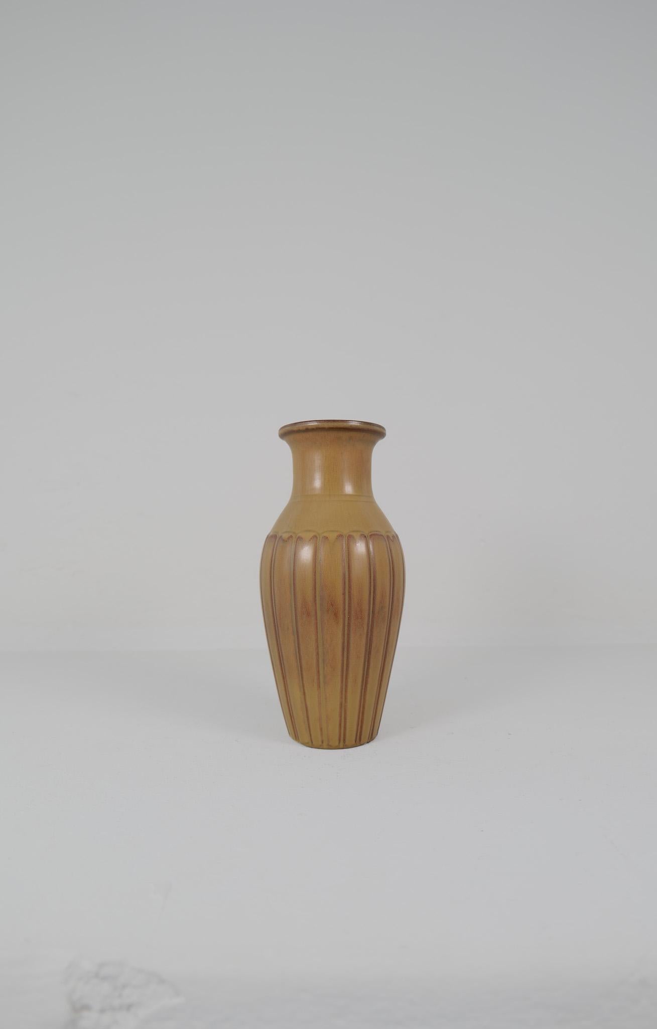 Ce grand vase inhabituel en grès de Gunnar Nylund pour Rörstrand 1950 est doté d'une glaçure harefur brun clair/vert/rouge. Il a en outre l'aspect époustouflant de l'excellent travail de Nylund. Il donne vraiment une bonne impression. 

Signé