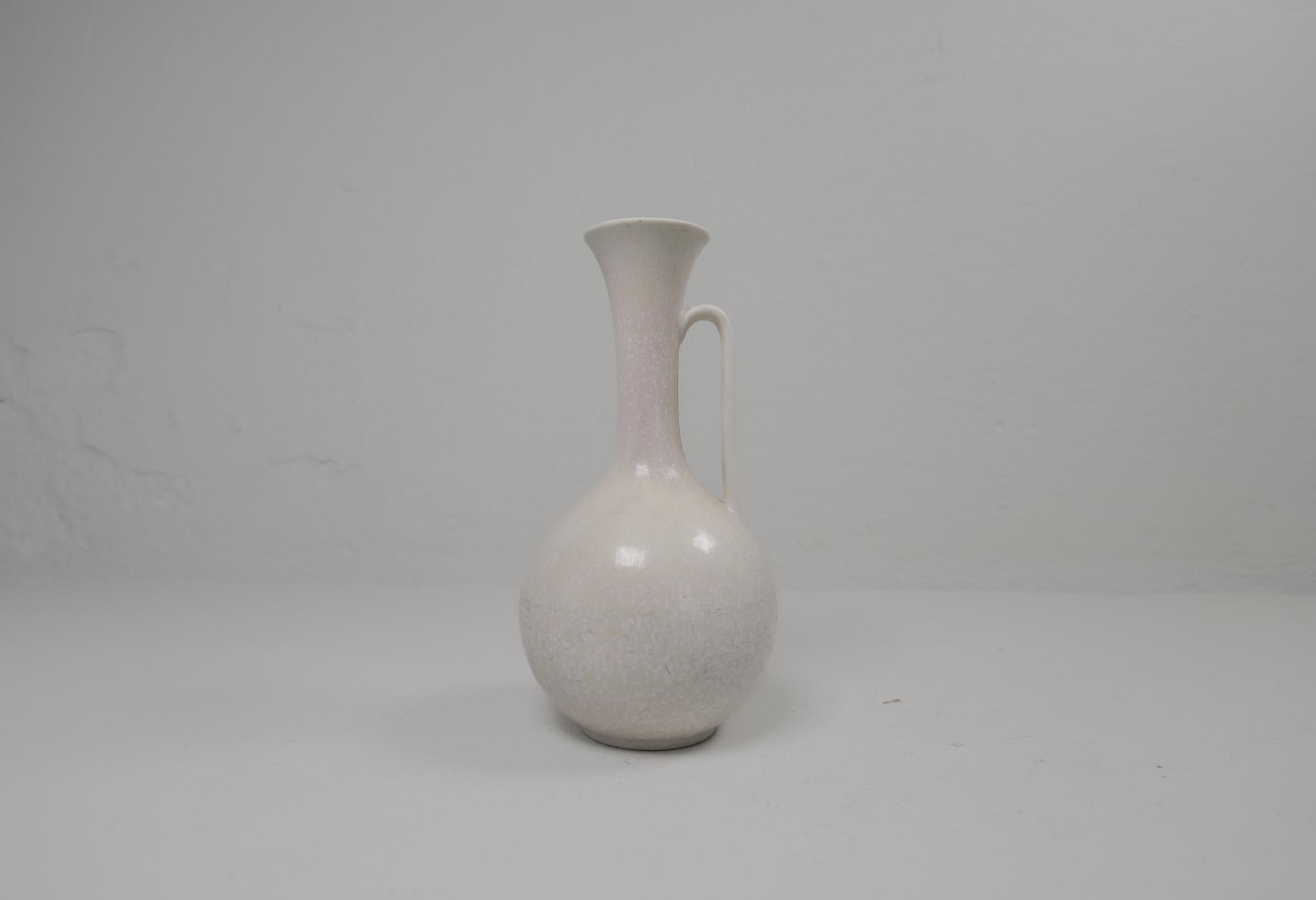 This large, unusual stoneware vase by Gunnar Nylund for Rörstrand, 1950s is gifted with light grey and white hare fur glaze with stains of pink. And it has that stunning look of Nylunds great craftsmanship. It really gives a great impression. 

Good