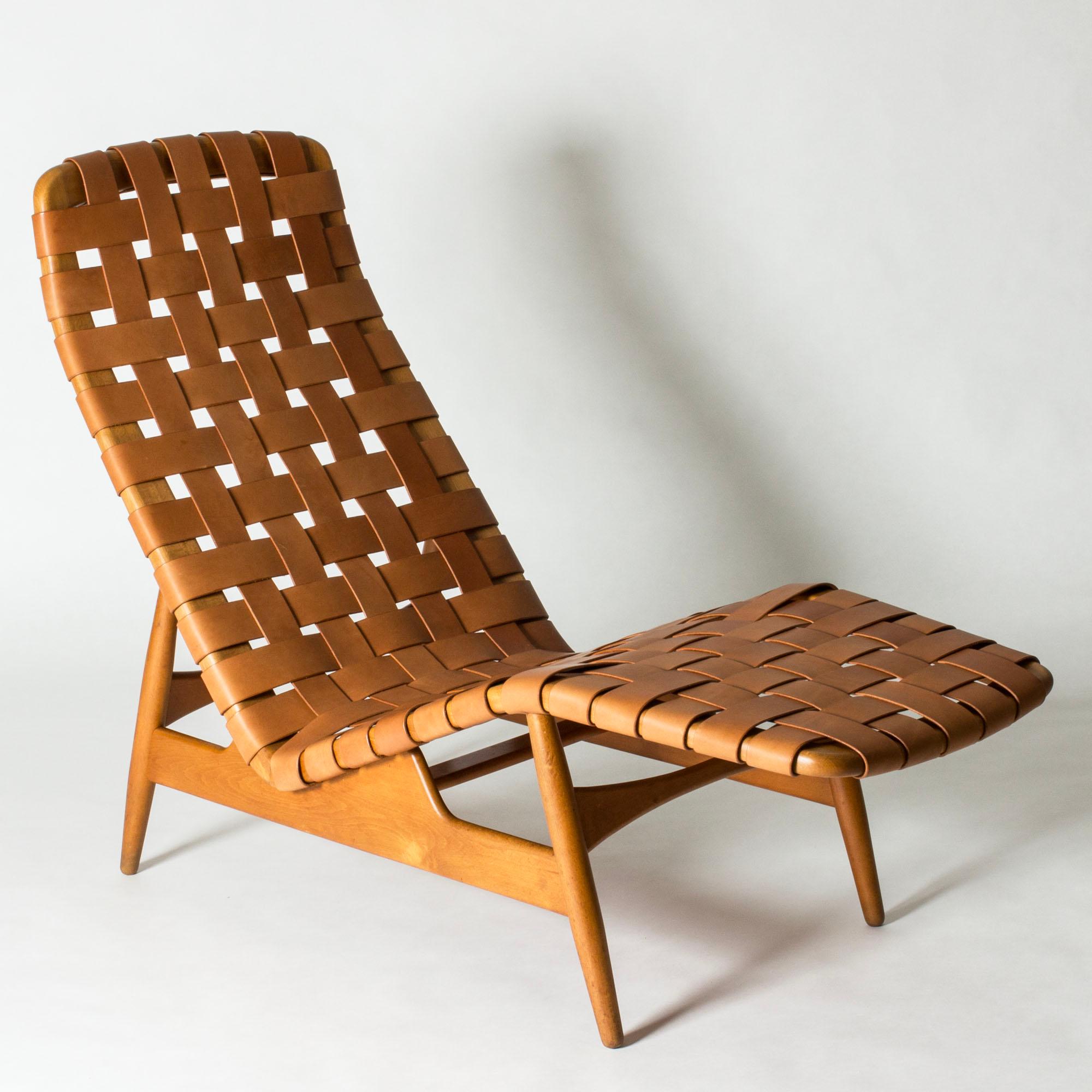 Striking chaise lounge by Arne Vodder, in a cool and elegant design with smooth lines. Made from oak with wreathed cognac colored leather straps. A beautiful teak tray, shaped to complement the form of the body, can be inserted into a hole in the