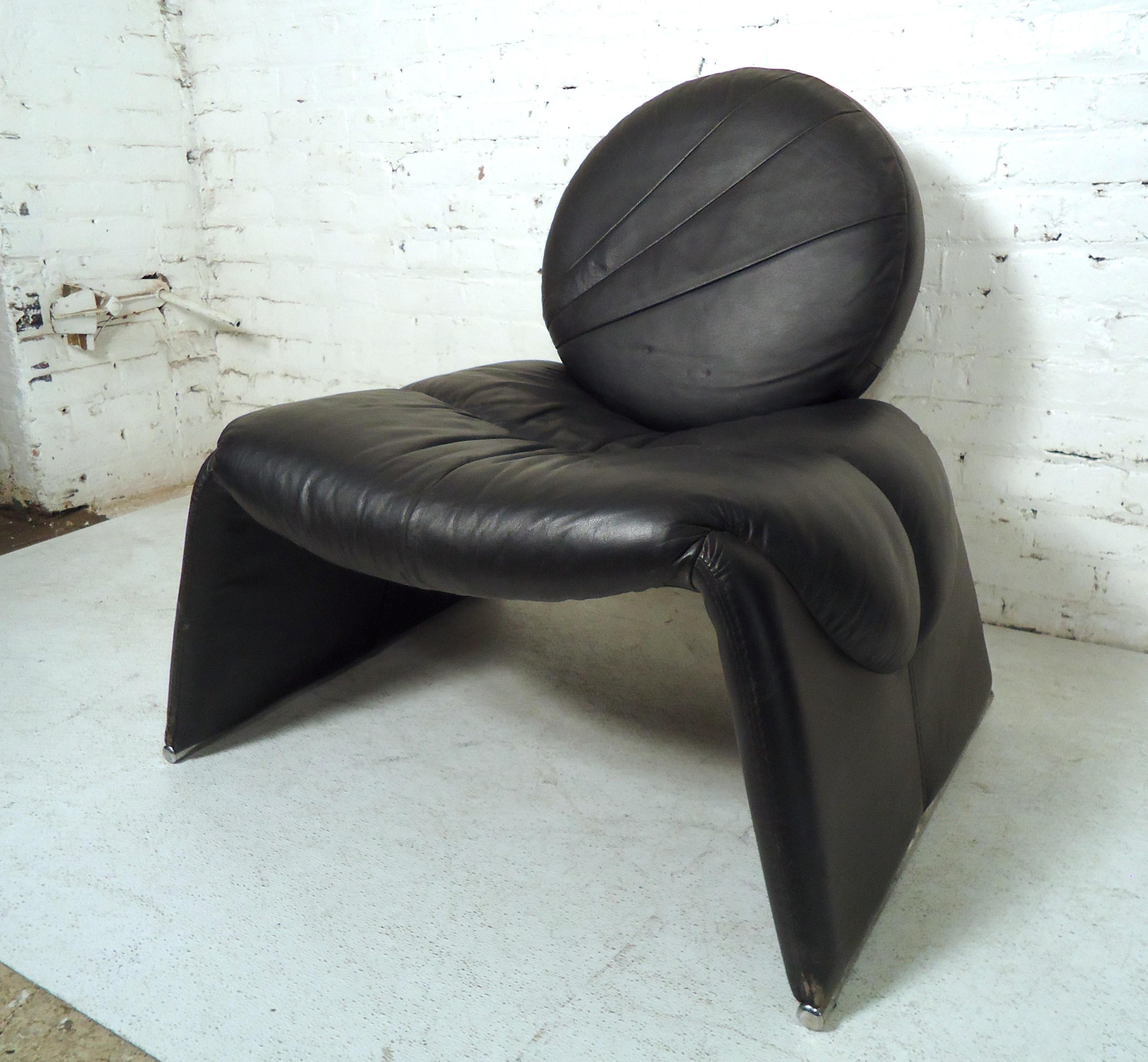 Vintage modern black leather lounge chair features, large cushion, an angled backrest and sides. This unique lounge chair makes the perfect addition to any modern interior. 

Please confirm item location (NY or NJ).
 