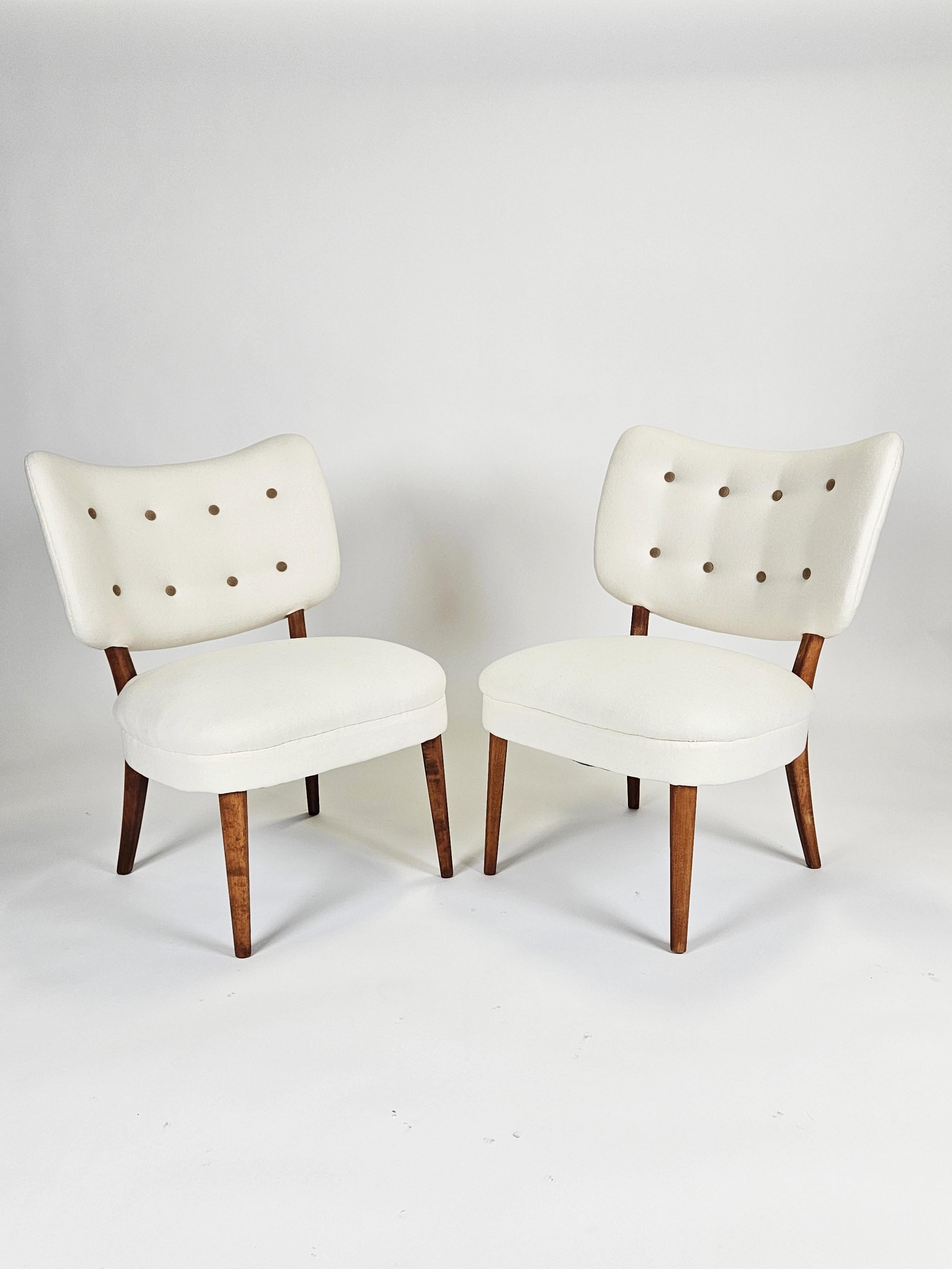 Elegant lounge chairs designed by Otto Schulz and produced by BOET in the 1940s. 

In the style of Scandinavian Modern. 

Beech frame with a wing back. Upholstered in white fabric with matching brown wool buttons. 