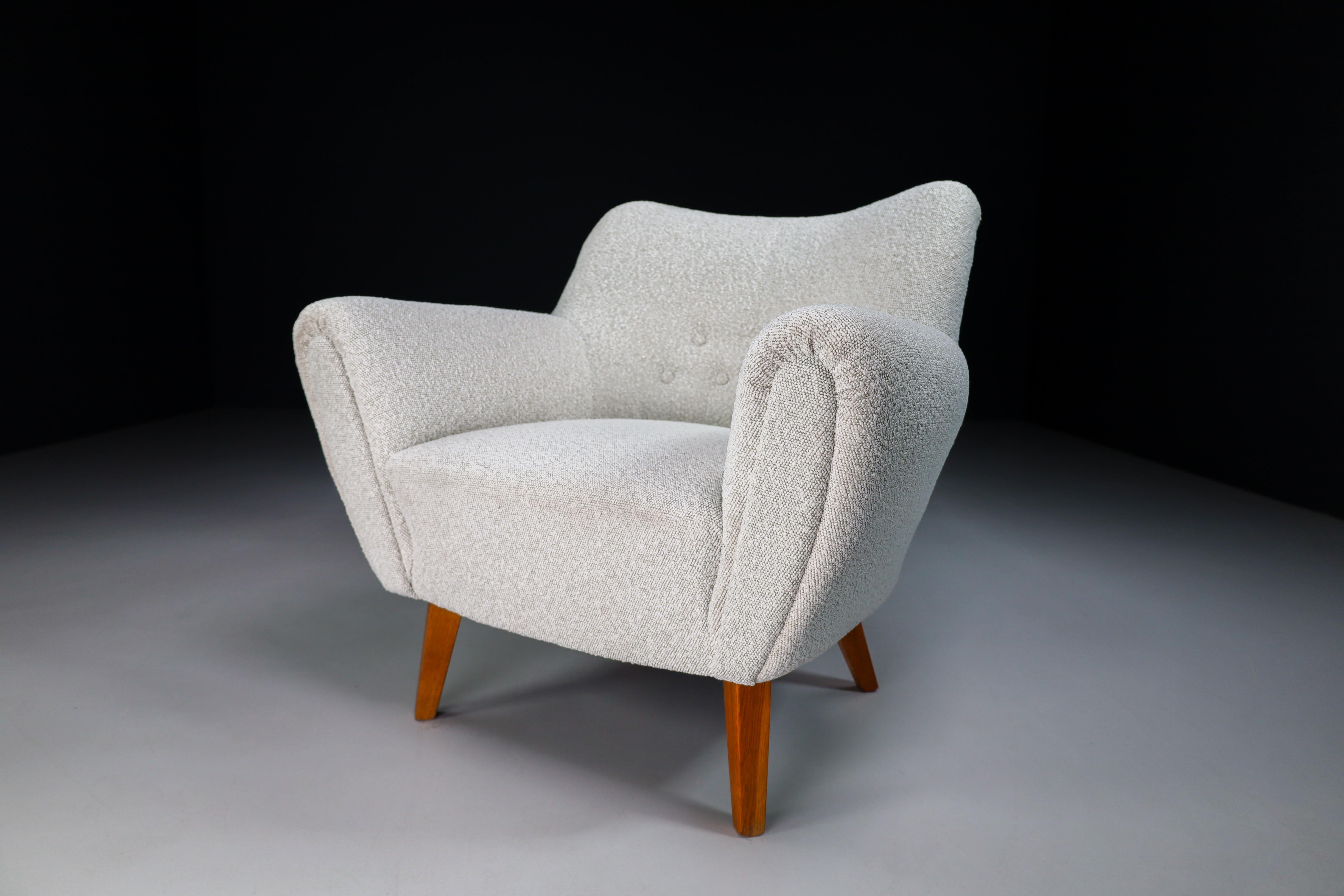 Chaises longues de style Mid-Century Modern fabriquées et conçues en France dans les années 1950. Réalisée en chêne français, cette chaise longue vient d'être retapissée avec du tissu Bouclé. Il est en parfait état vintage, petite patine sur les