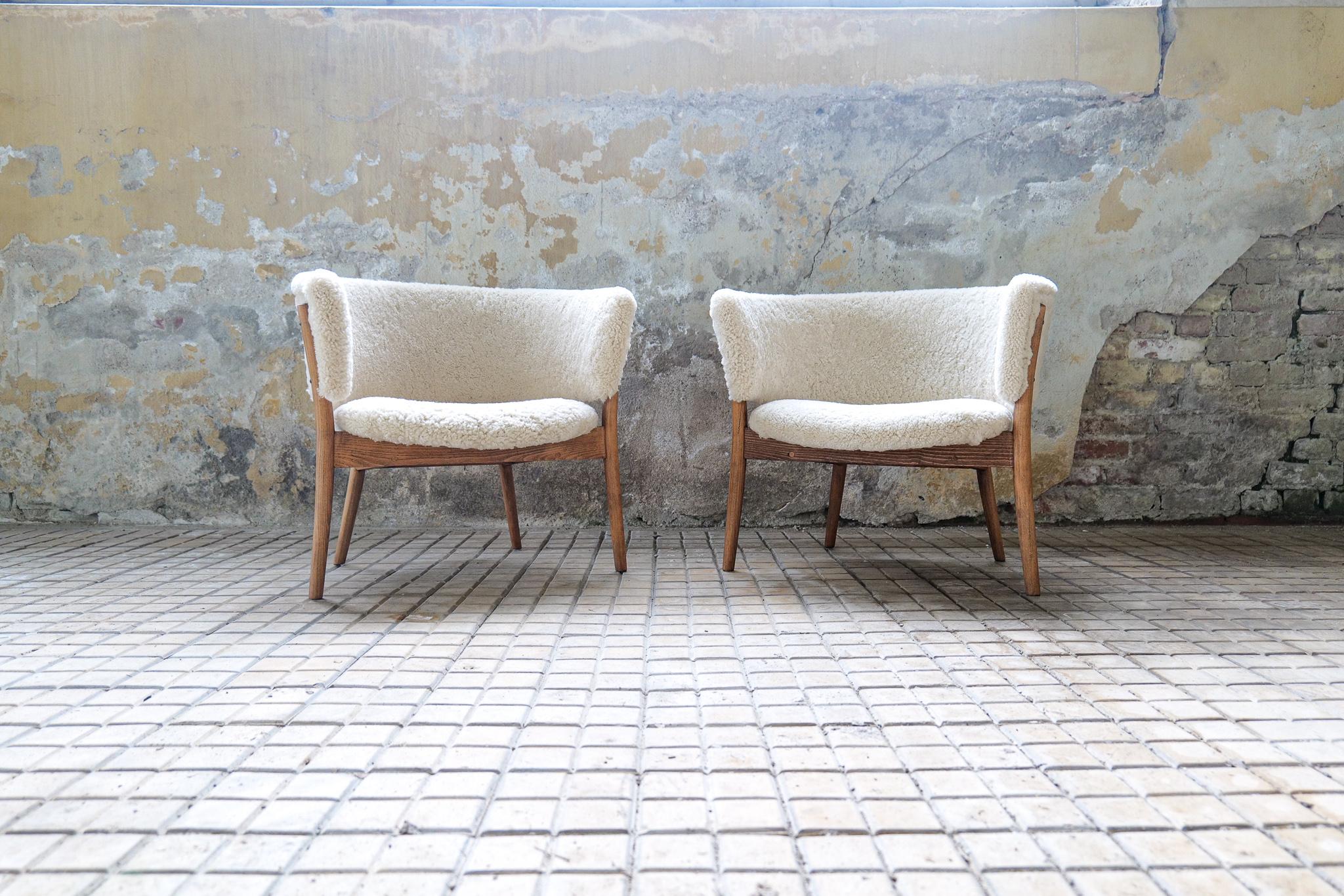 These two wonderfully crafted chairs were made in Sweden 1962 and design by Erik Wörts. The chairs made in stained birch and sheepskin has been redone both in the wooden part as well all new upholstery with quality sheepskin. The skin itself is made