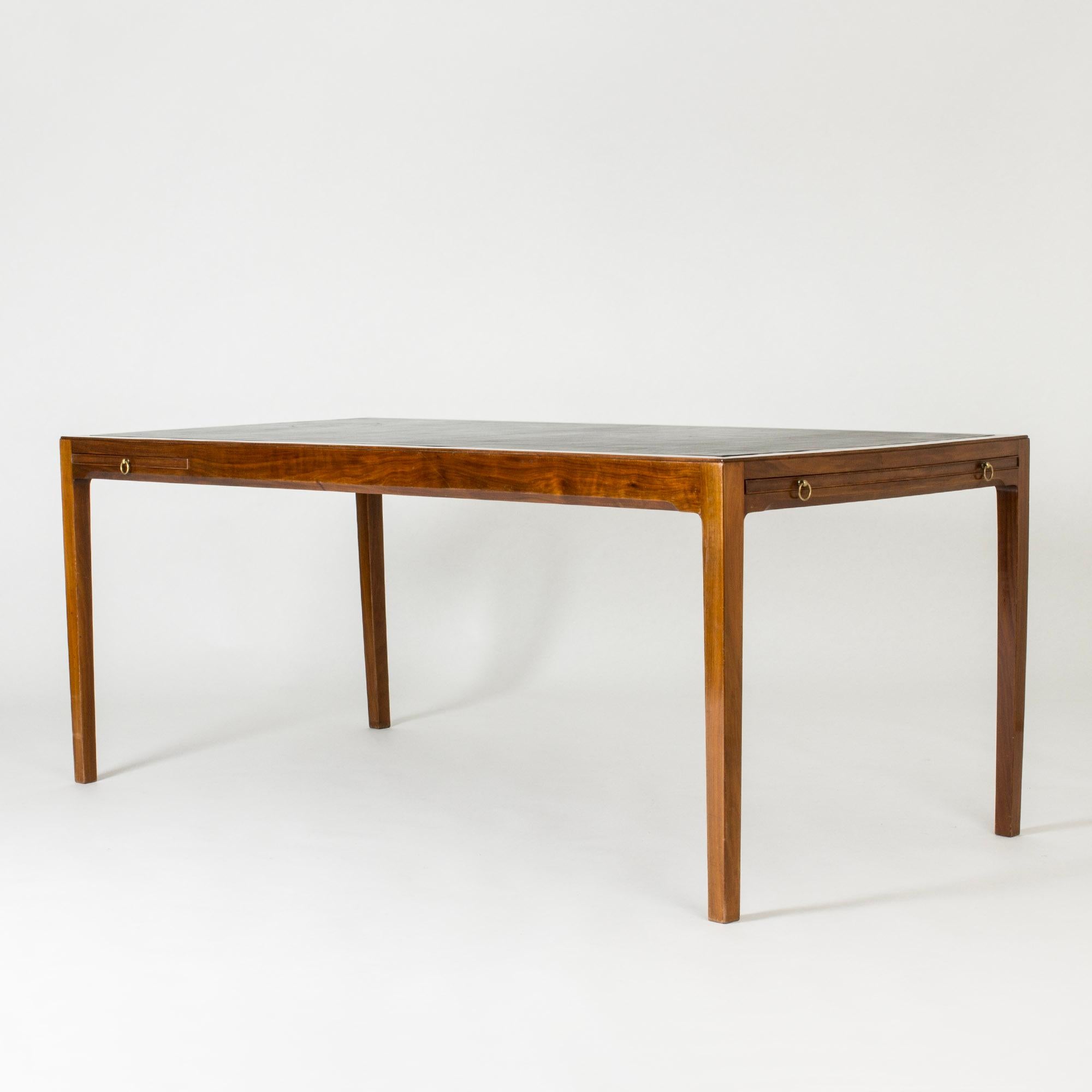 Straordinaria scrivania di Ole Wanscher, realizzata in mogano con piano in pelle nera. Linee molto eleganti e dettagli sofisticati. Cerchi in ottone per estrarre le estensioni sul lato e su una delle estremità corte.