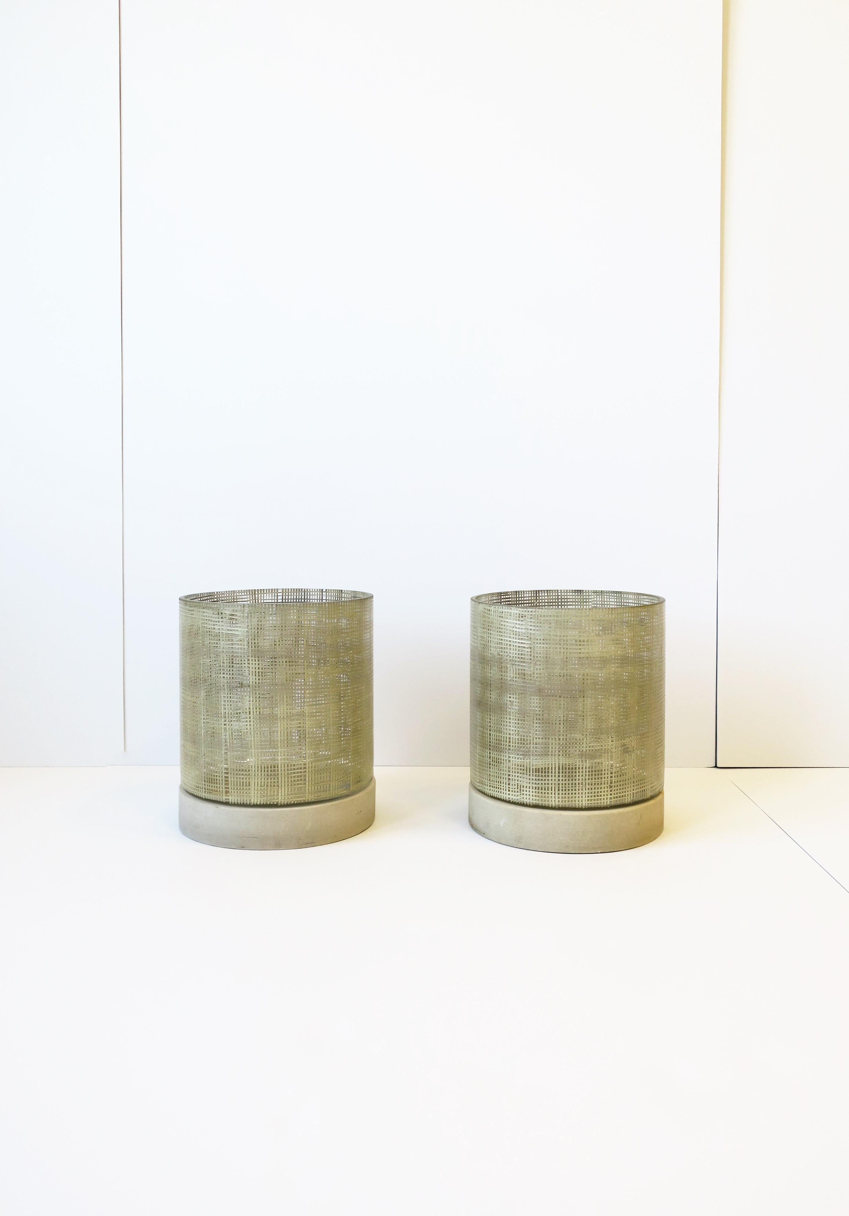 A beautiful pair of Minimalist style glass and stone hurricane candle lamps, circa late-20th century to early 21st century. The design and textured art glass give this set a bit of Midcentury Modern look and feel, and the stone bases add a bit of a