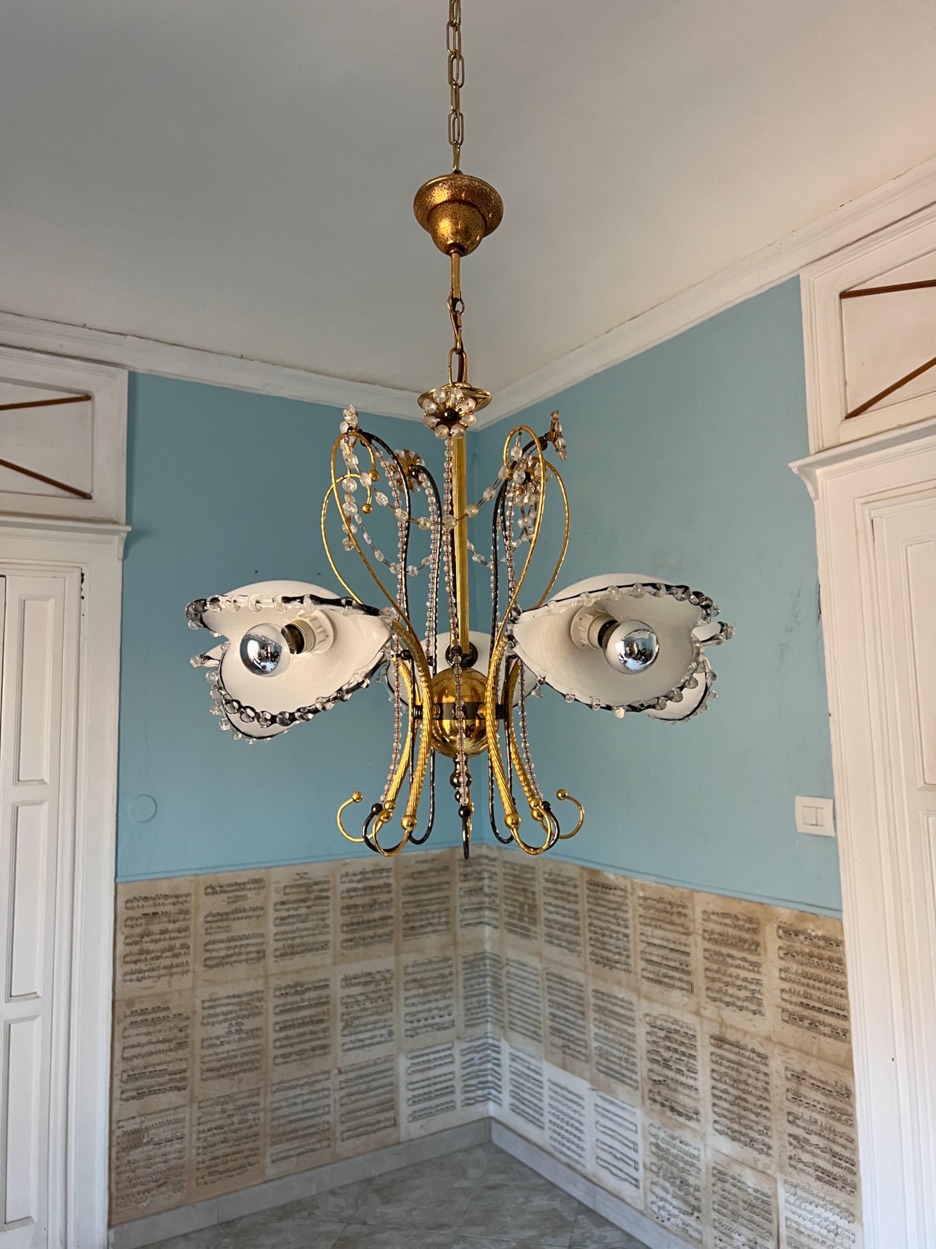 Lampadario in vetro di Murano unico nel suo genere, risalente agli anni '80. I suoi sorprendenti paralumi sono realizzati in vetro di Murano bianco e nero con bordi trasparenti finemente smerlati, molto dettagliati e di ottima fattura. La base è in