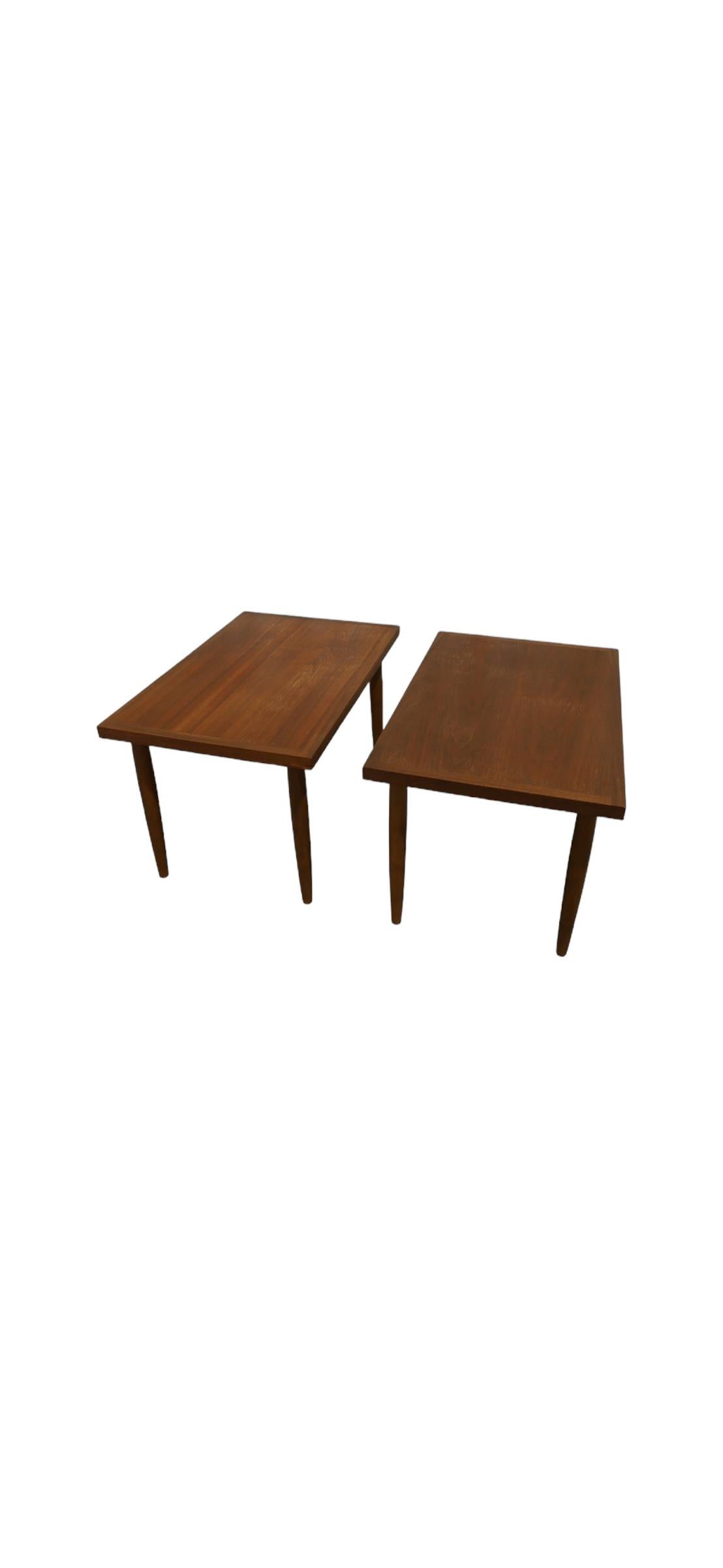 Elegant midcentury modern nightstands or end tables. Executed in walnut with rectangular surface, framed top, and tapered legs. Attractive and efficient silhouette with plenty of room for large lamps, books, art, and the like. All surfaces have been