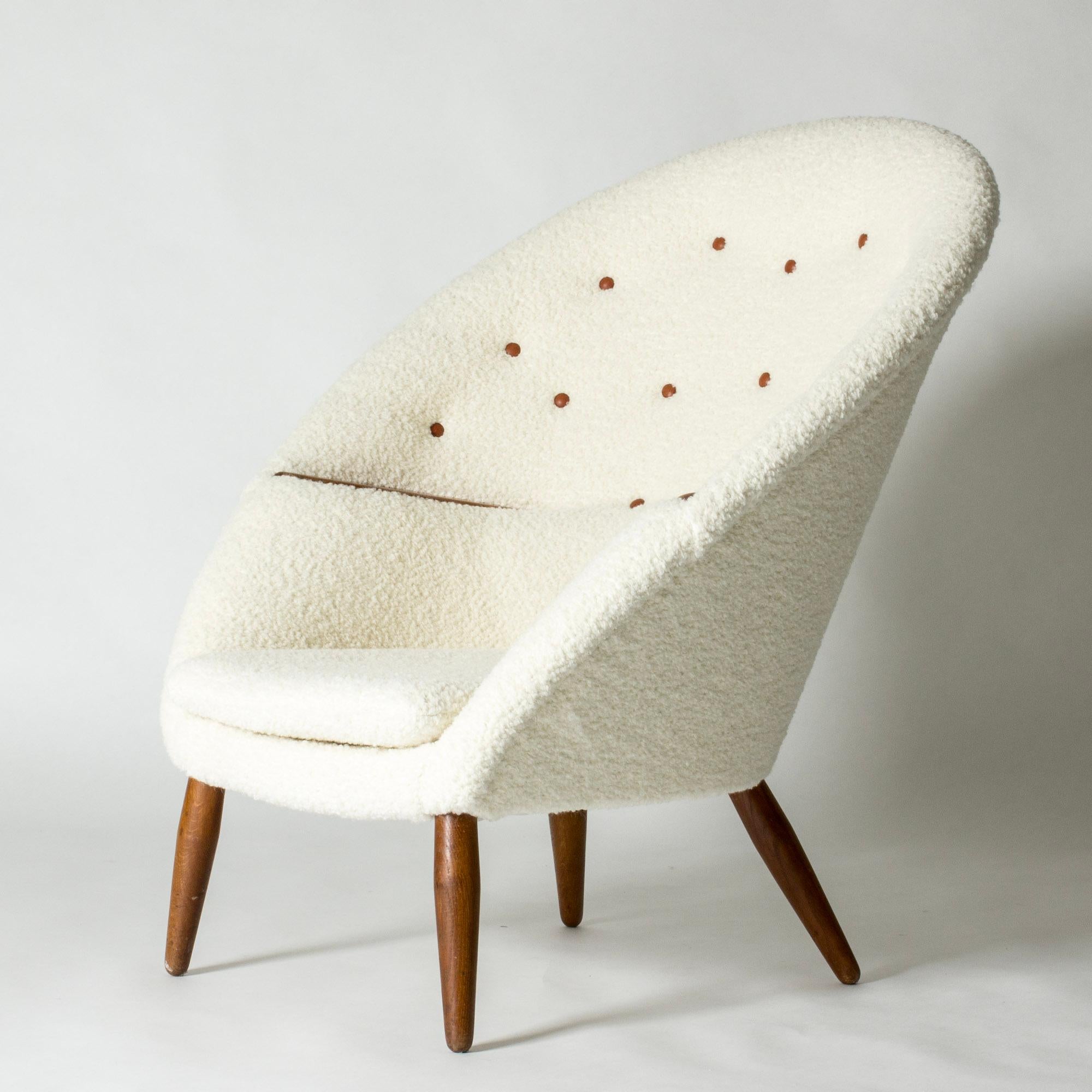 Amazing “MS-9” or “Oda” lounge chair by Arnold Madsen, with a striking round silhouette. Cocoon model with decorative teak details on the arms. Upholstered with bouclé fabric, leather dressed buttons in the back.