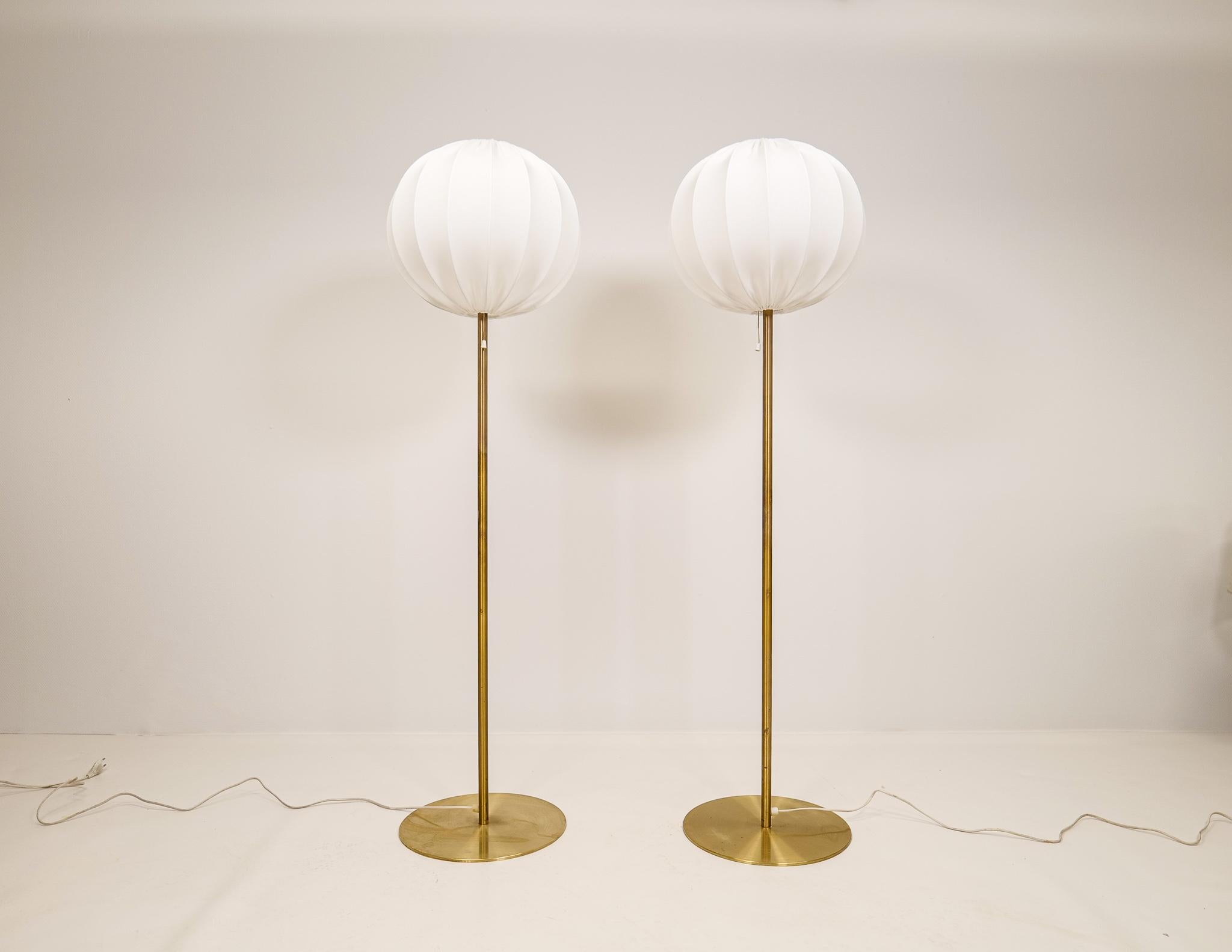 These Mid-Century Modern floor lamps were manufactured in Sweden for Luxus. The rounded base and rod are made in brass. These lamps come with both the new cotton cloud rounded shades made in Sweden as well as the original upplight shades in acrylic.