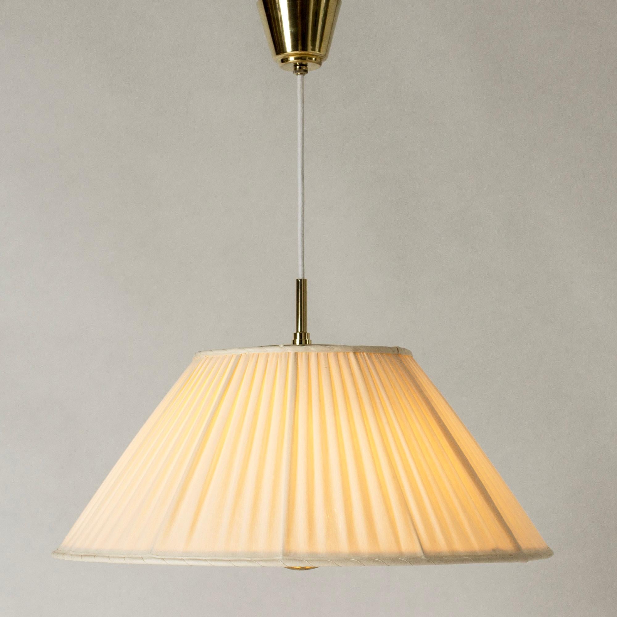 Beautiful brass pendant light by Josef Frank, in an elegant, voluminous design. Shade made from pleated fabric. A decorative brass “anchor” comes out through the bottom of the shade and can be pulled to adjust the length of the chord.

Length of