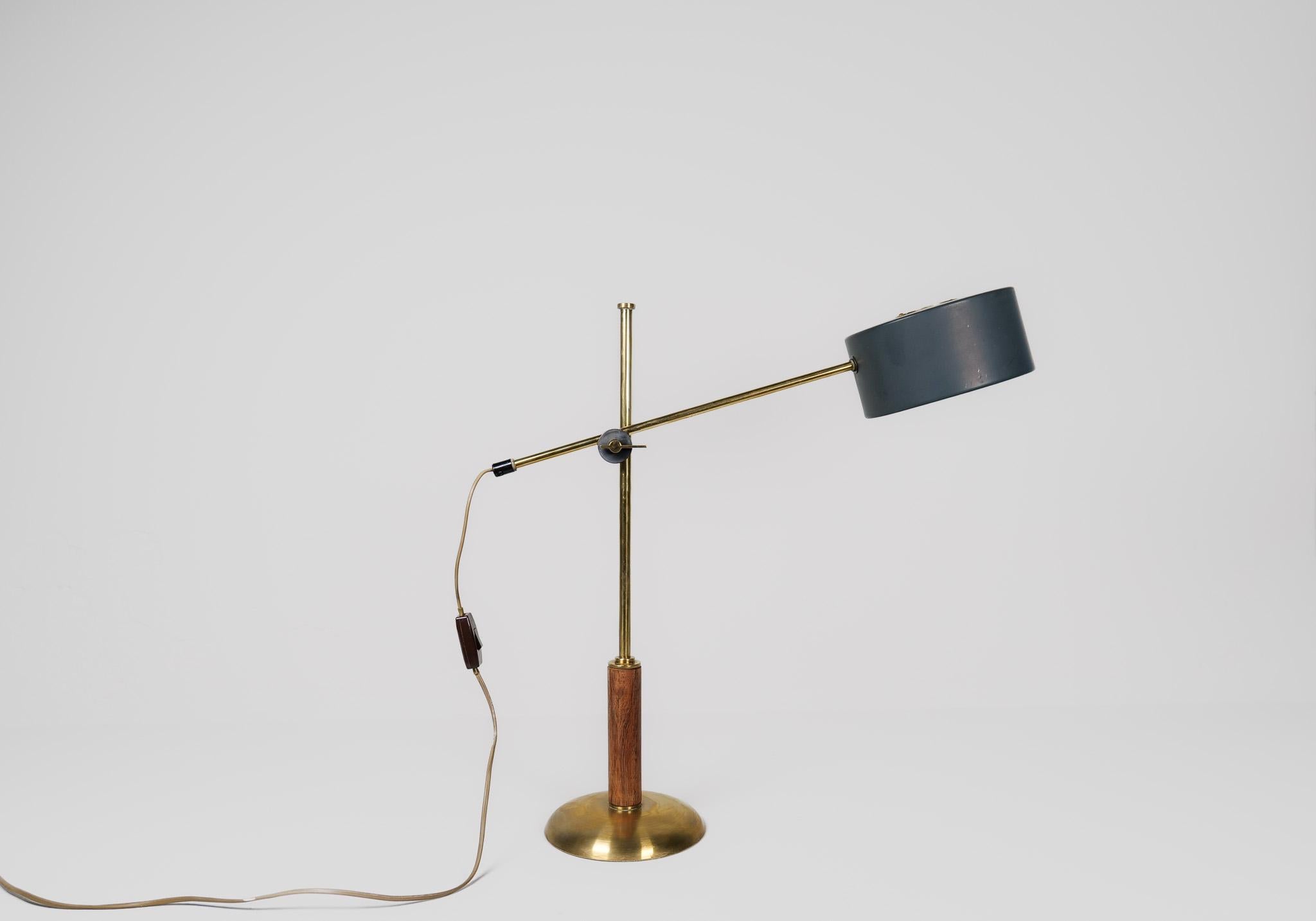 This rare table lamp produced in Sweden and designed by Einar Bäckström is adjustable in both height and angles. 
Brass base with walnut rod and a lacquered shade with brass details. 

Good vintage condition with some wear to the shade.