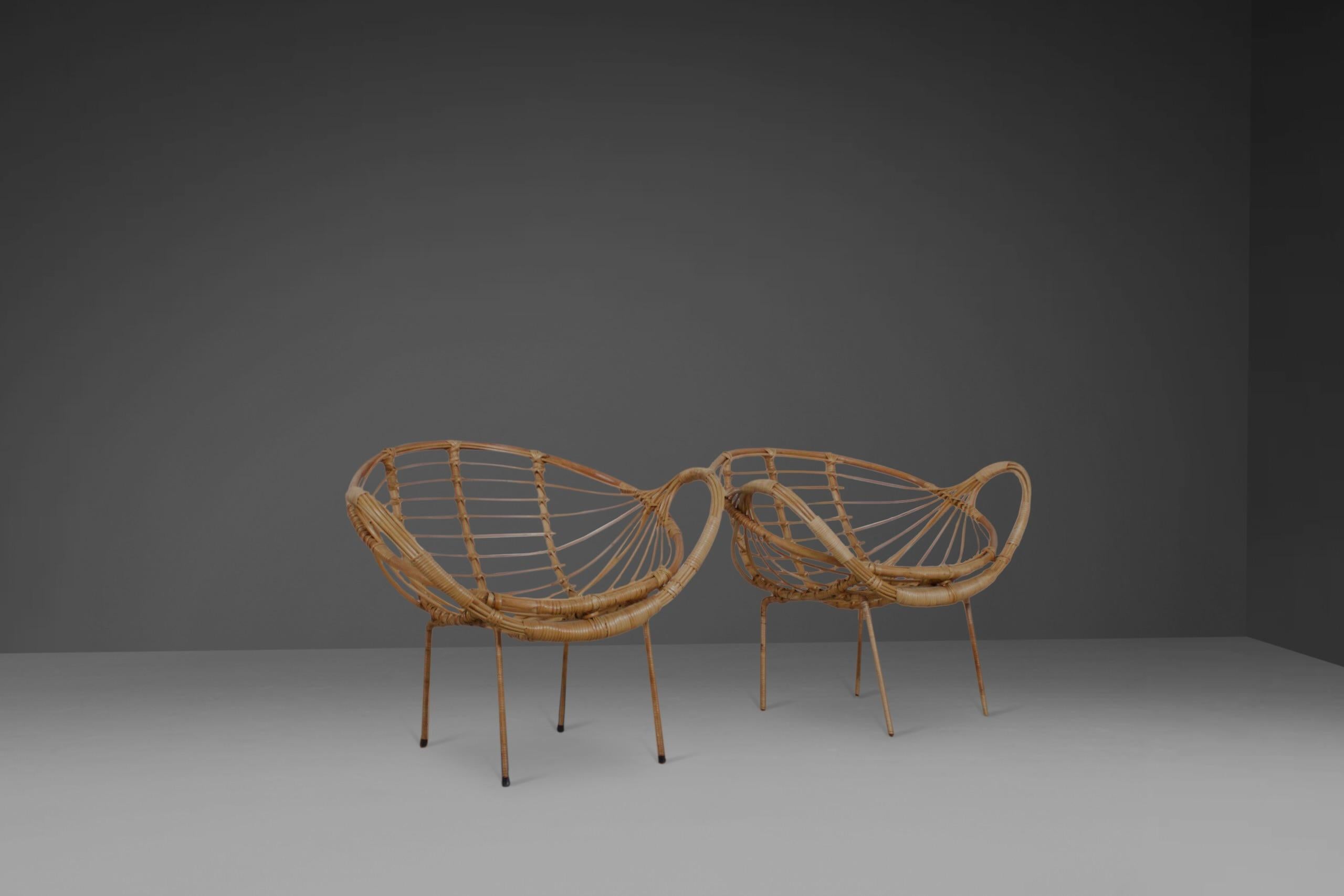 Set of sculptural rattan armchairs in very good condition.

The chairs have an elegant basket form seat and large rounded armrests.

The frame is made from steel and is covered in rattan.

The chairs have been fully restored by a rattan