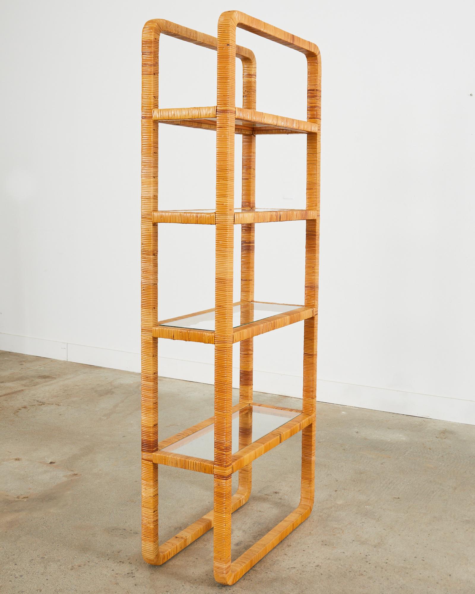 Stylish Mid-Century Modern four-shelf etagere or bookcase featuring a rattan wrapped frame made in the manner and style of Bielecky Brothers with gracefully curved corners. The shelves are inset of flush mounted with fitted glass shelves. The