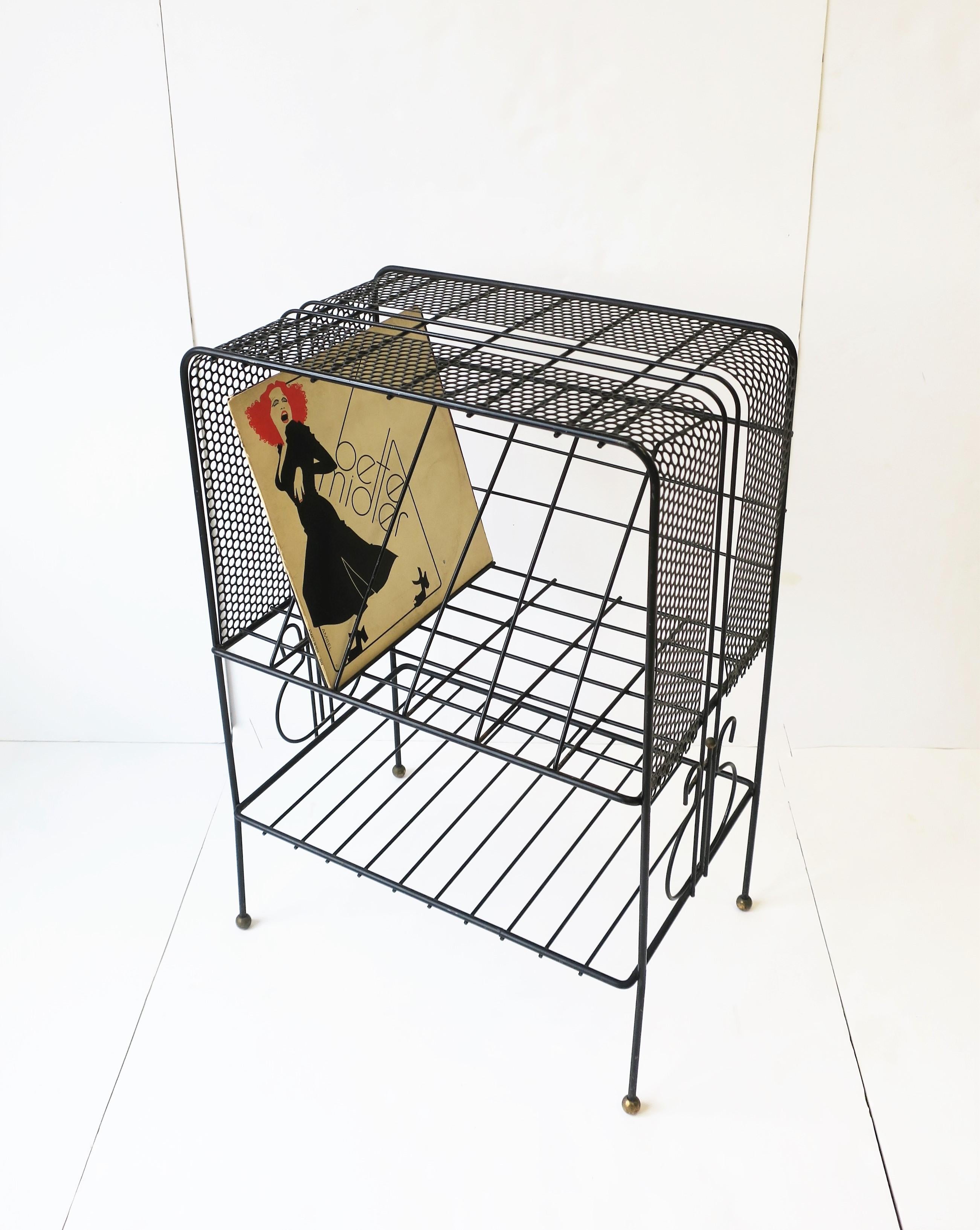 A Mid-Century Modern black record player and LP vinyl album metal holder rack stand table, circa mid-20th century, USA. Piece can support player and albums with more storage space at bottom with shelf (shown with books.) There are six (6) 3