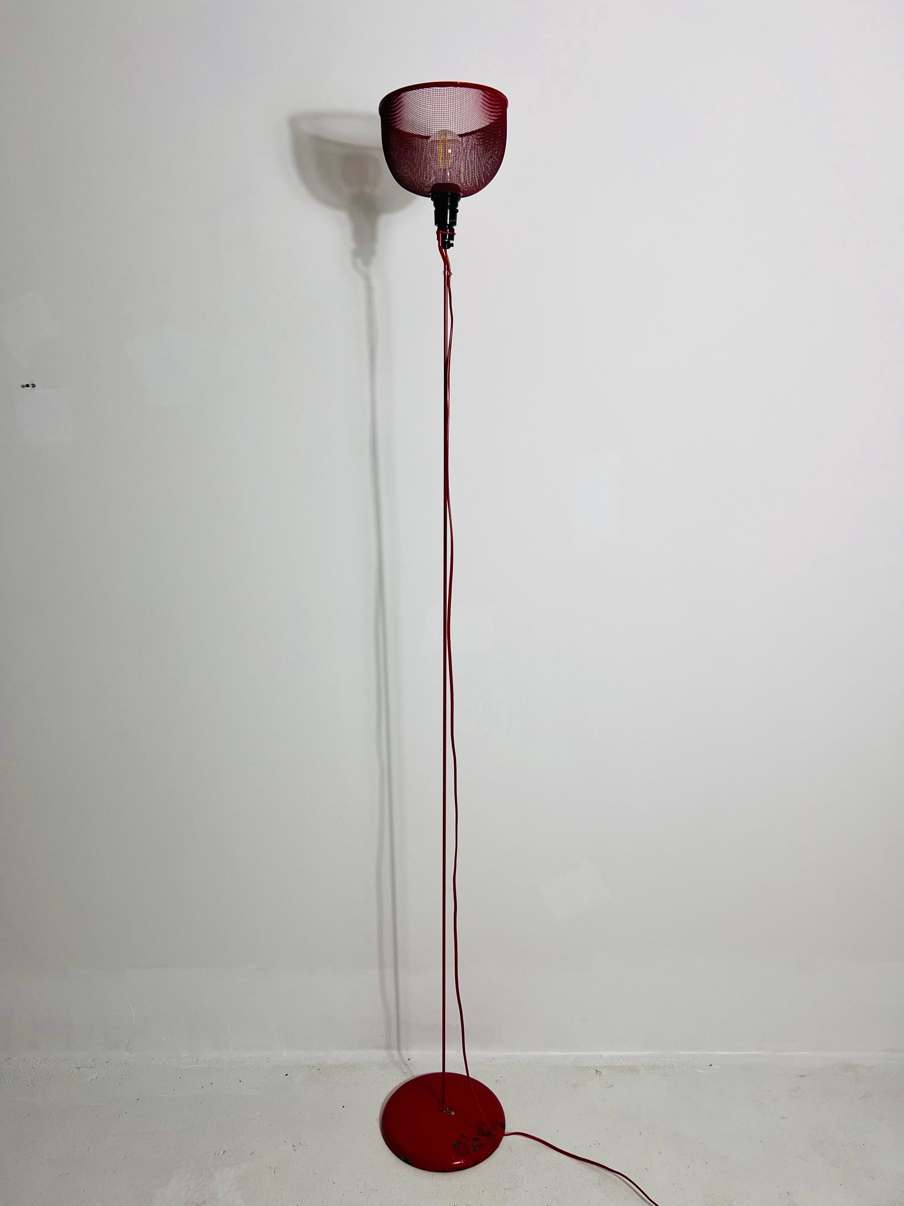 Ce remarquable lampadaire italien des années 1970 capture l'esthétique audacieuse et futuriste du design de l'âge de l'espace. La lampe se caractérise par une tige centrale élégante et ultra-mince, de couleur rouge vif, qui se prolonge gracieusement