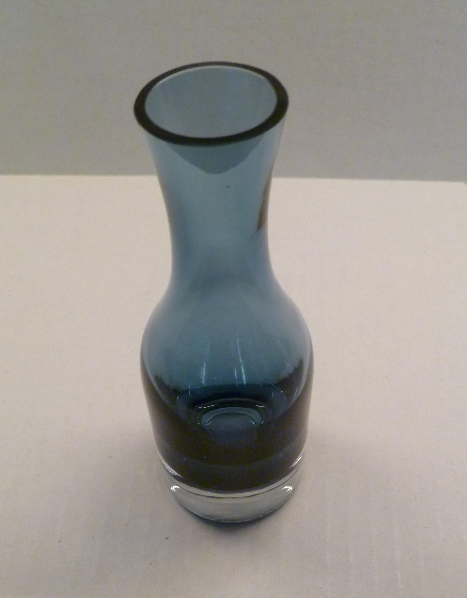 Mid-Century Modern blown glass vase from the Riihimaki glass factory in Finland from 1951.  Small size with a heavy clear vase with a beautiful smoke-blue colored body.

Riihimäki was founded in 1910 and became the largest glass factory in Finland