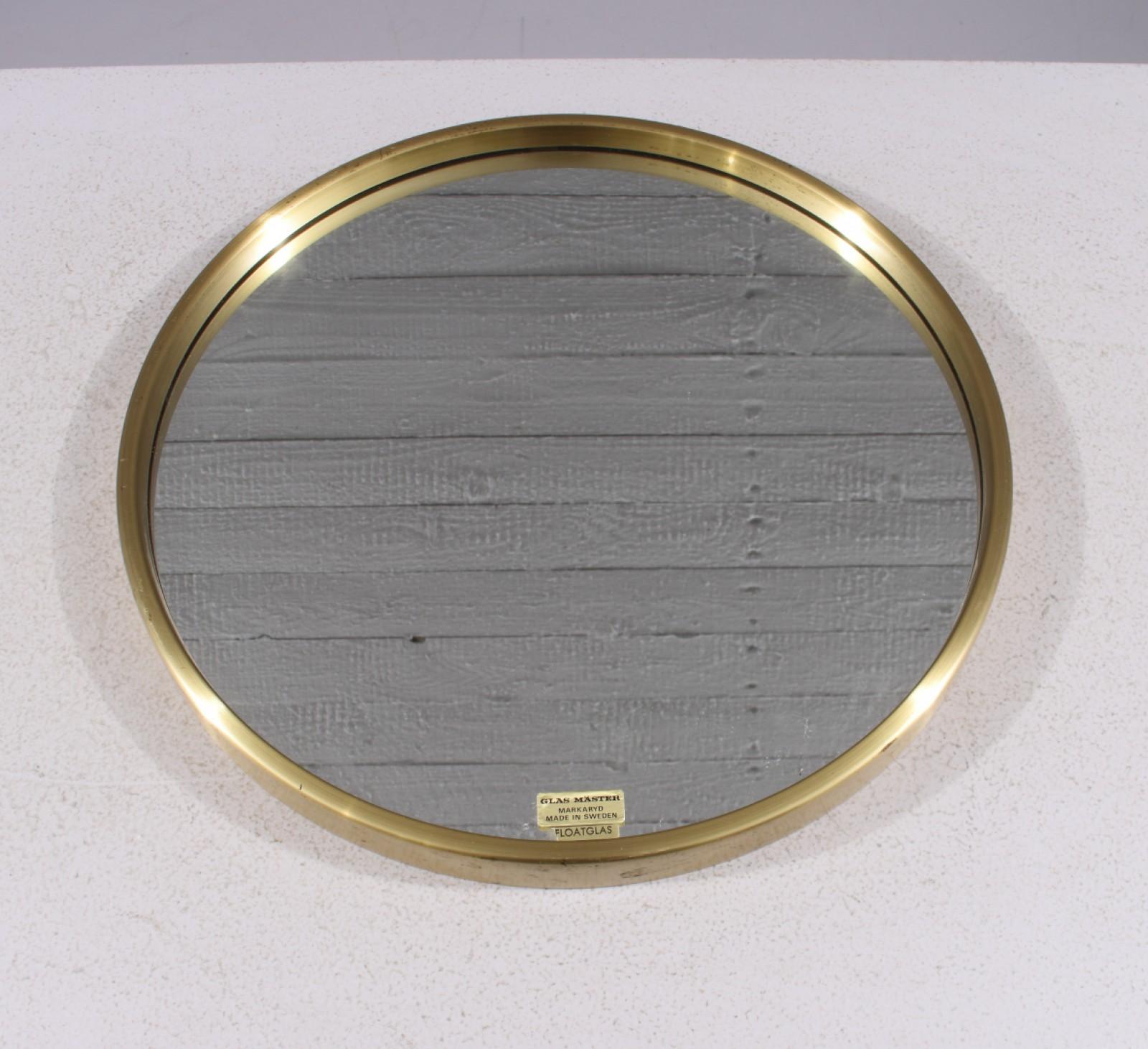 Questo elegante specchio rotondo in ottone, modello 132, è stato prodotto da Glas Mäster a Markaryd, Svezia, negli anni '60. La struttura in ottone e il vetro float combinano un design elegante con la qualità artigianale tipica dello stile moderno
