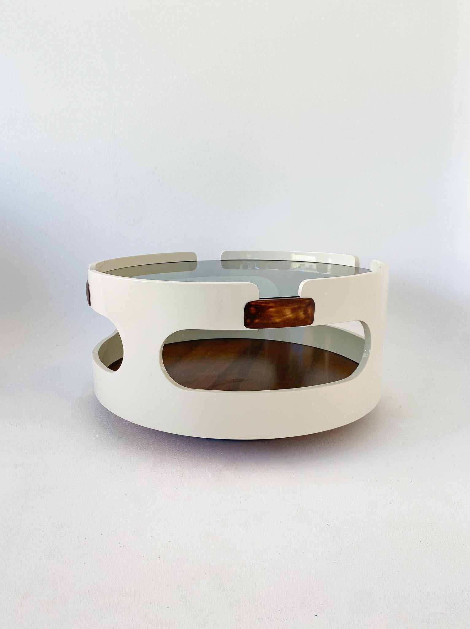 Mid Century Modern round white wooden coffee table, Italy 1970s.
 
This lovely coffee table features a characteristic round form in laquered white wood with cut outs and wonderful brown wooden elements. The top of the table is made of grey smoked