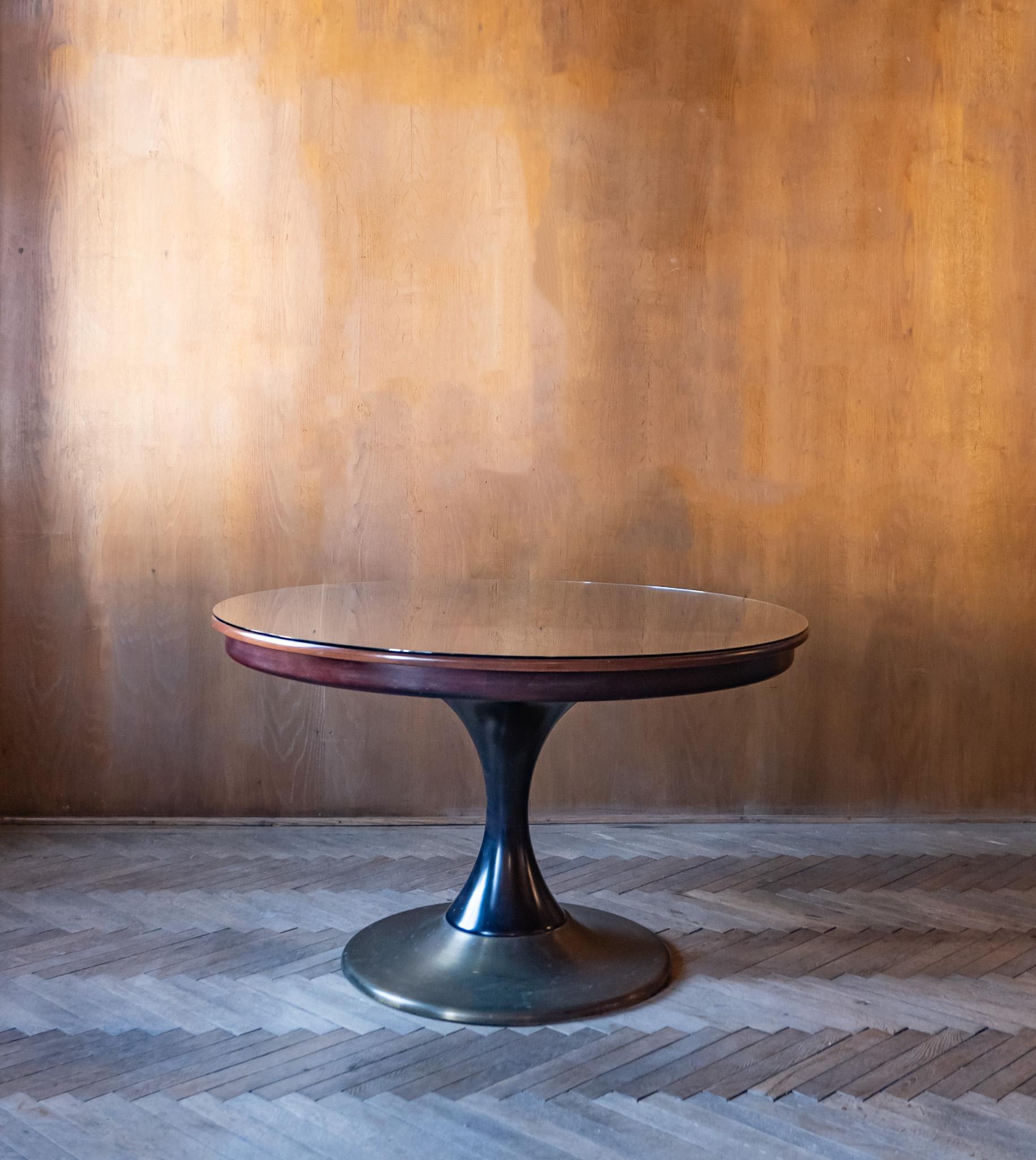 Mid-century Modern round wooden brass dining table, Italy 1950s.

This elegant Italian dining table in wonderful brown tones. consists of a table top and table base in walnut and brass. The wooden table top is additionally protected by a glass top