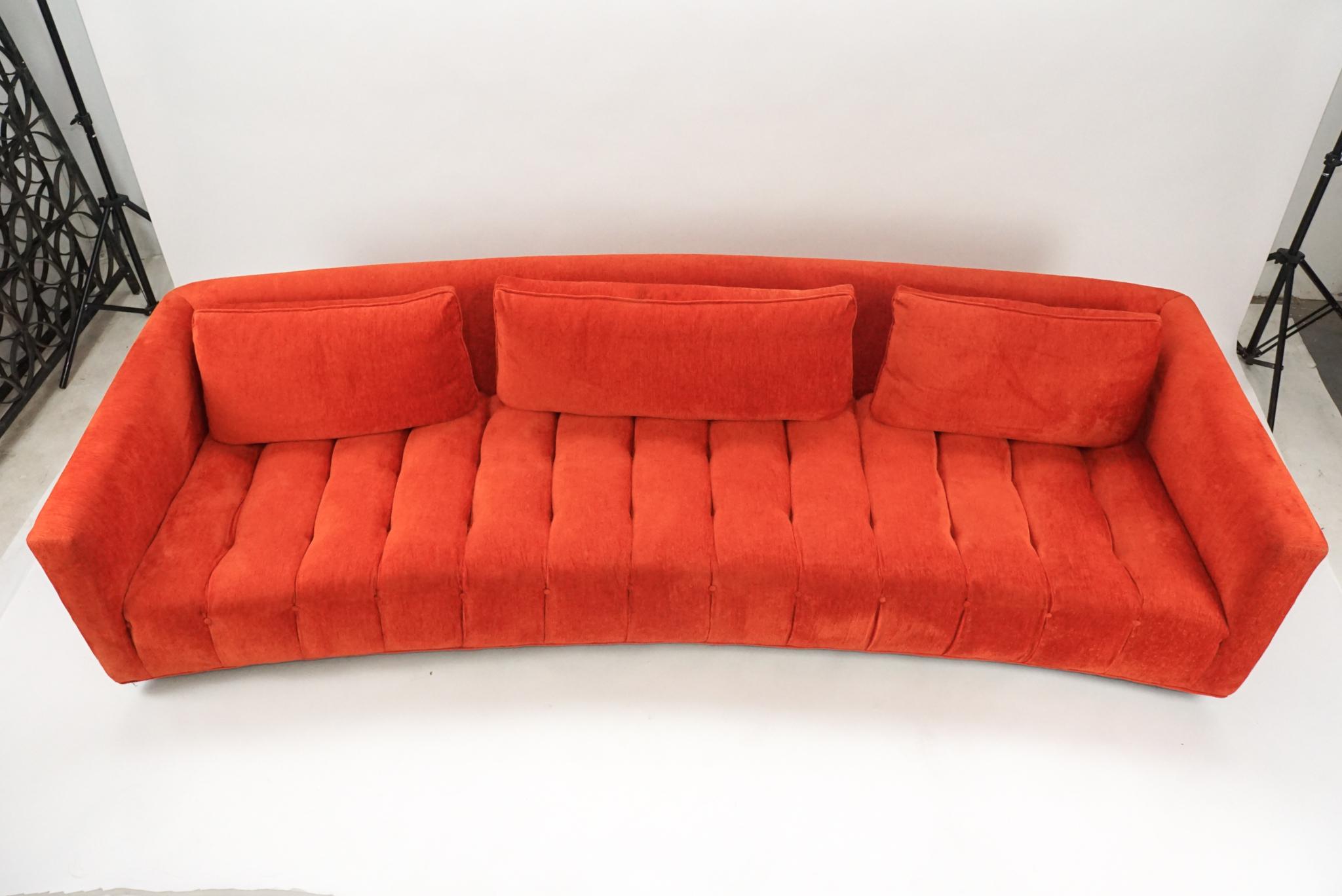 Sculptural curved sofa by Erwin-Lambeth. This piece was recovered a few years back in a stunning red chenille type upholstery. The bottom of the sofa was done in blue! Attention to detail is incredible. This piece is a real showstopper on top of