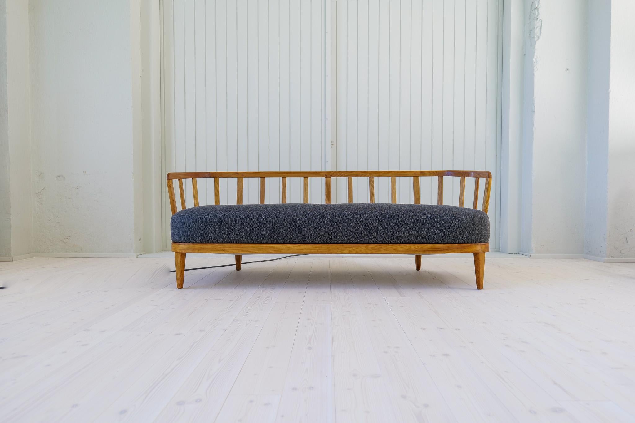 This Rare model” Värend” sofa was designed by Carl Malmsten in the 1940s. The sofa has been reupholstered. Stained elm, back with ribs, loose back cushions and upholstered seat, covered in grey fabric. We choose to show the sofa mostly with the back