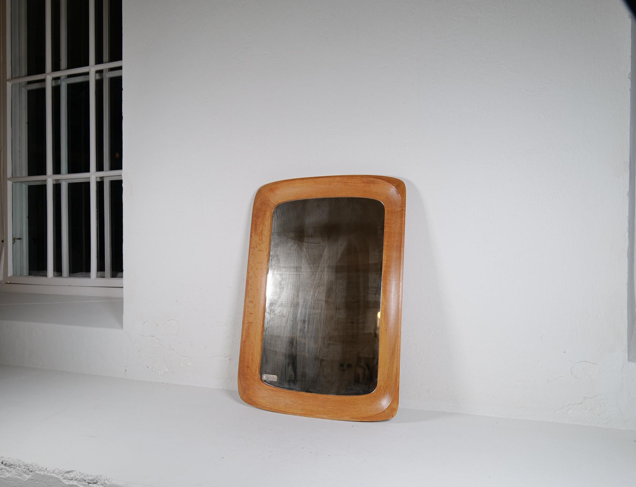 Wonderful organic wall mirror produced by AB Glas & Trä, Hovmantorp, Sweden. In sculpted oak and crystal mirror glass, labeled. 

Good vintage condition, with some scratches on the wood, distressed/dizzy glass.

Dimensions: Height: 37.41 in. (95 cm)