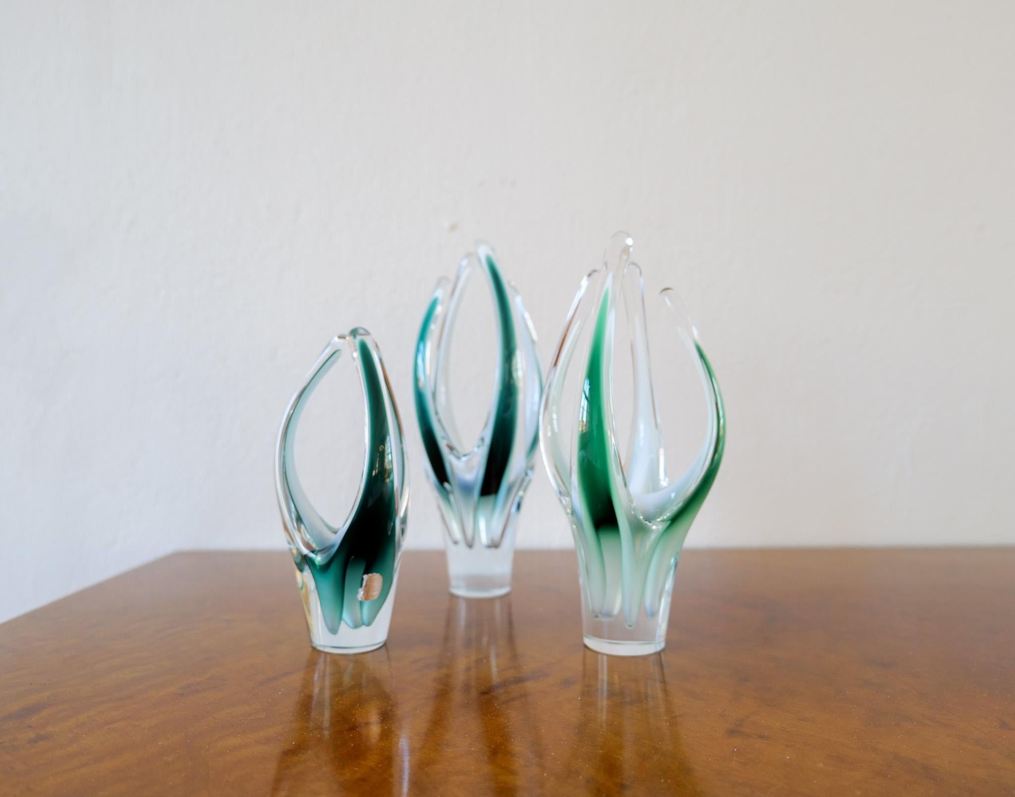 Un conjunto de 3 piezas de vidrio artístico maravillosamente esculpidas. Todos ellos se desplazan en cristal verde, blanco y transparente. Fabricadas en Suecia a mediados de la década de 1950, estas piezas aportan un aspecto moderno y llamativo.