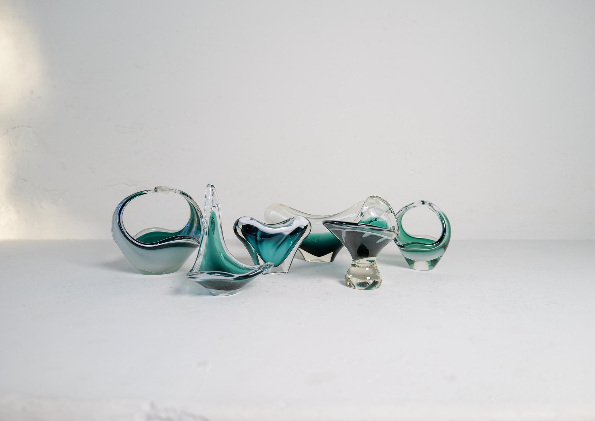 Un conjunto de 6 piezas de vidrio artístico maravillosamente esculpidas. Todos ellos se desplazan en cristal verde, blanco y transparente. Fabricadas en Suecia a mediados de la década de 1950, estas piezas aportan un aspecto moderno y llamativo.