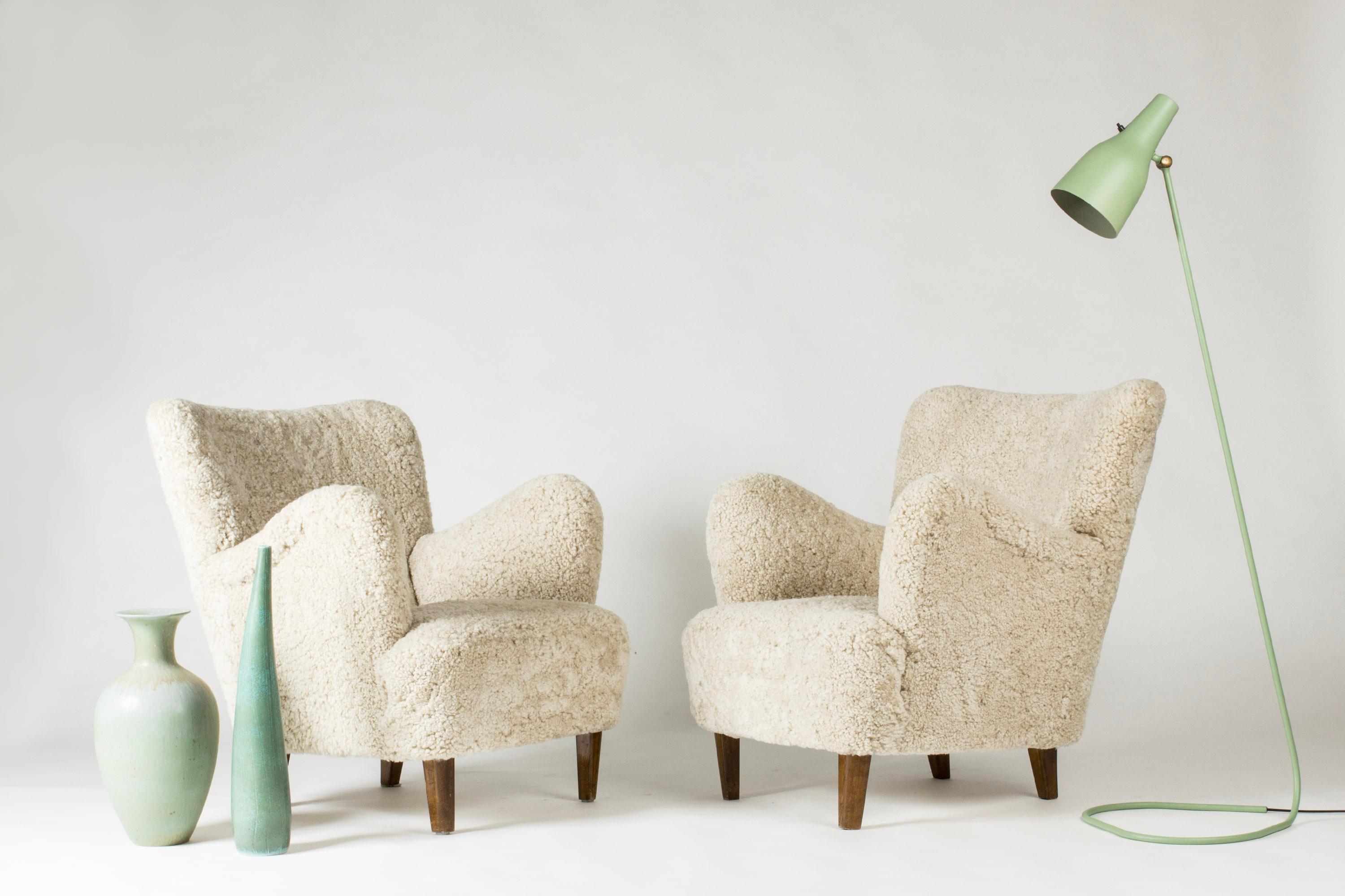 Pair of beautiful Swedish Modern lounge chair, in a neat, easy to place size and very comfortable to relax into. Upholstered with sheepskin.