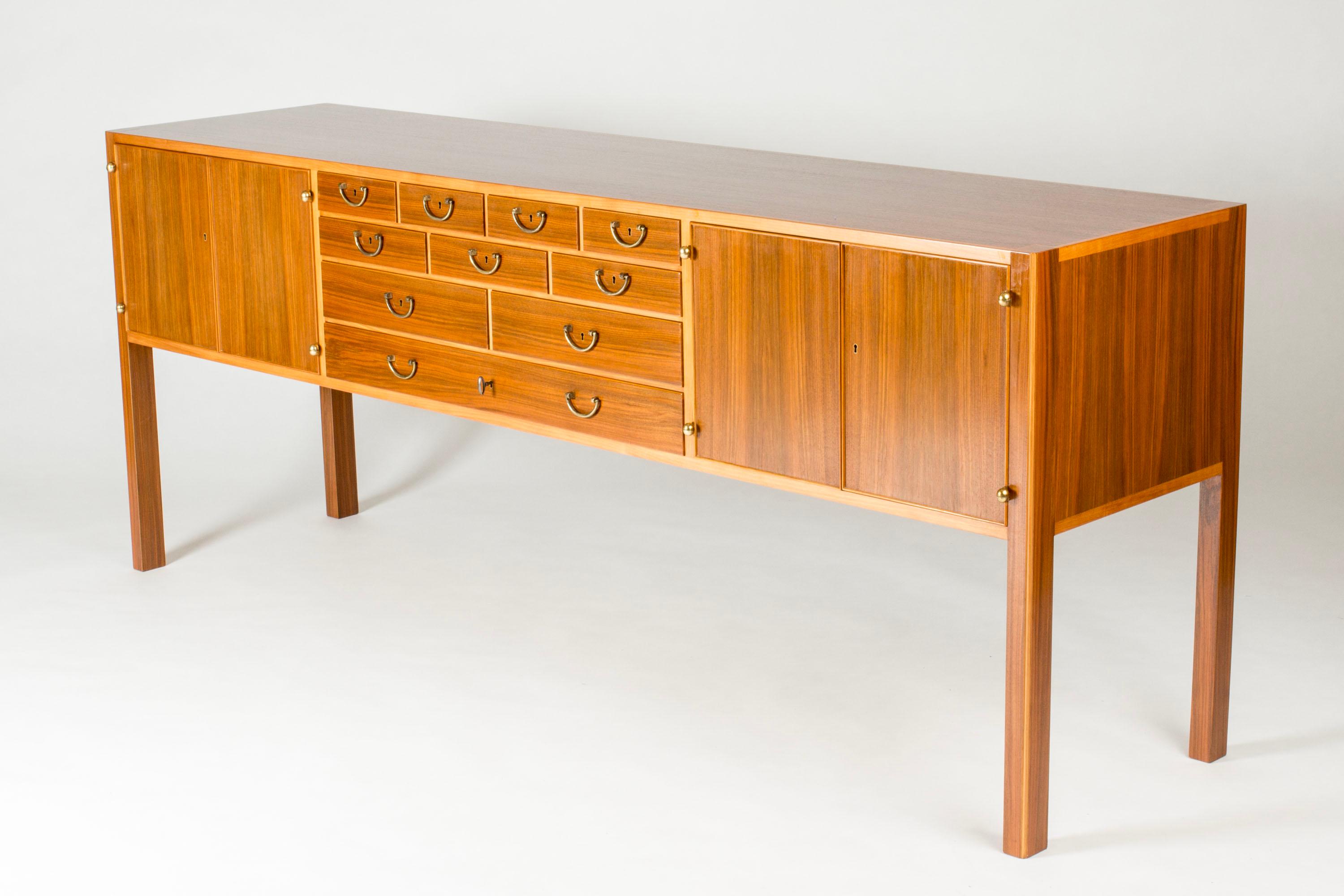 Superbe buffet de Josef Franks, d'un design rare avec plusieurs tiroirs et des détails décoratifs. Fabriqué en acajou avec des poignées et des charnières en laiton. Ligne incrustée de bois plus clair sur le pourtour du plateau du buffet.
