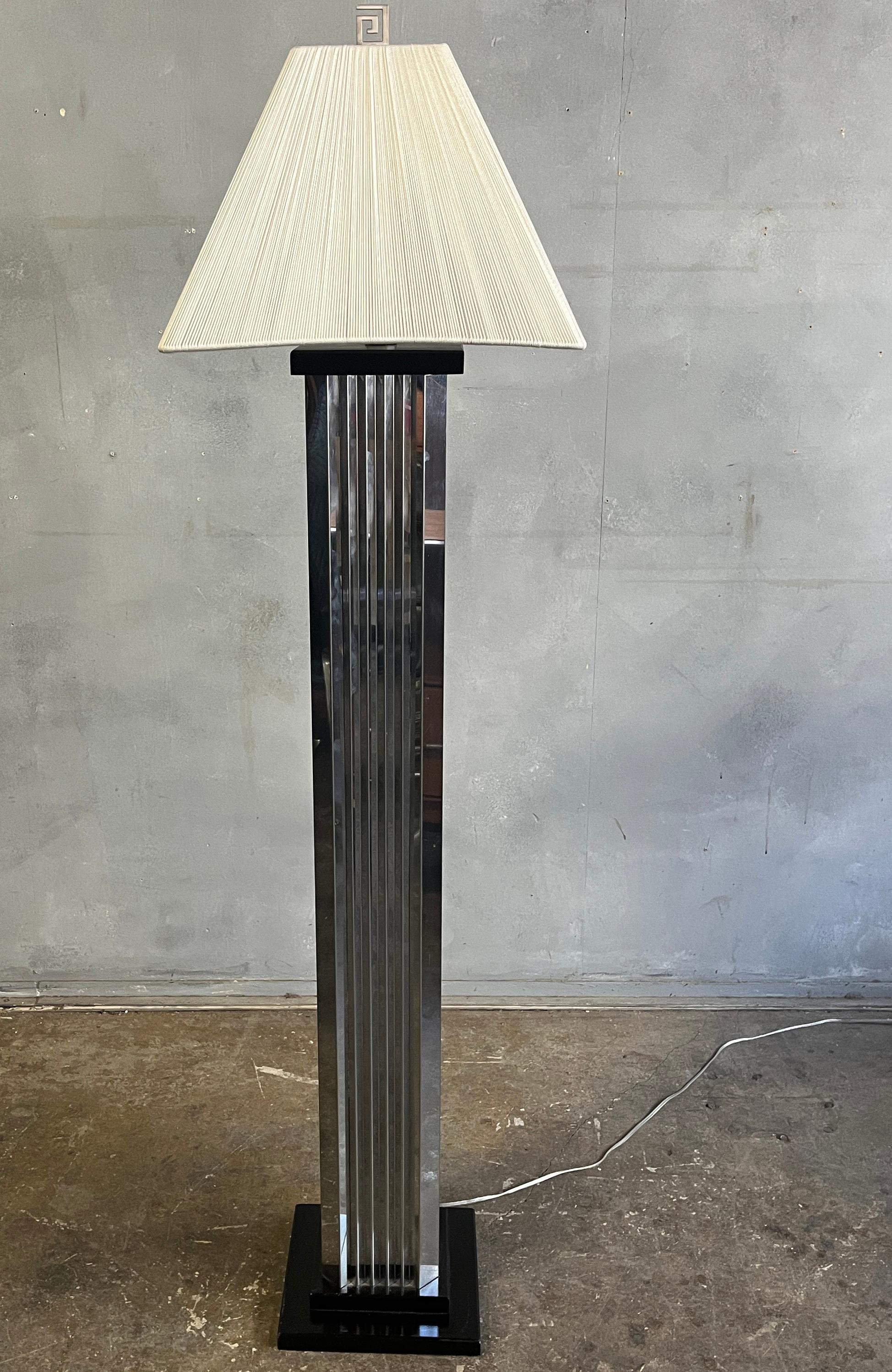 Vintage 1980s or 1970s Art Deco/Hollywood Regency floor lamp. This lamp has thin chrome metal panels with a mirrored finish in an accordion fold attached to an ebony lacquered base. We believe the shade is made of silk strings. Silvered hardware.