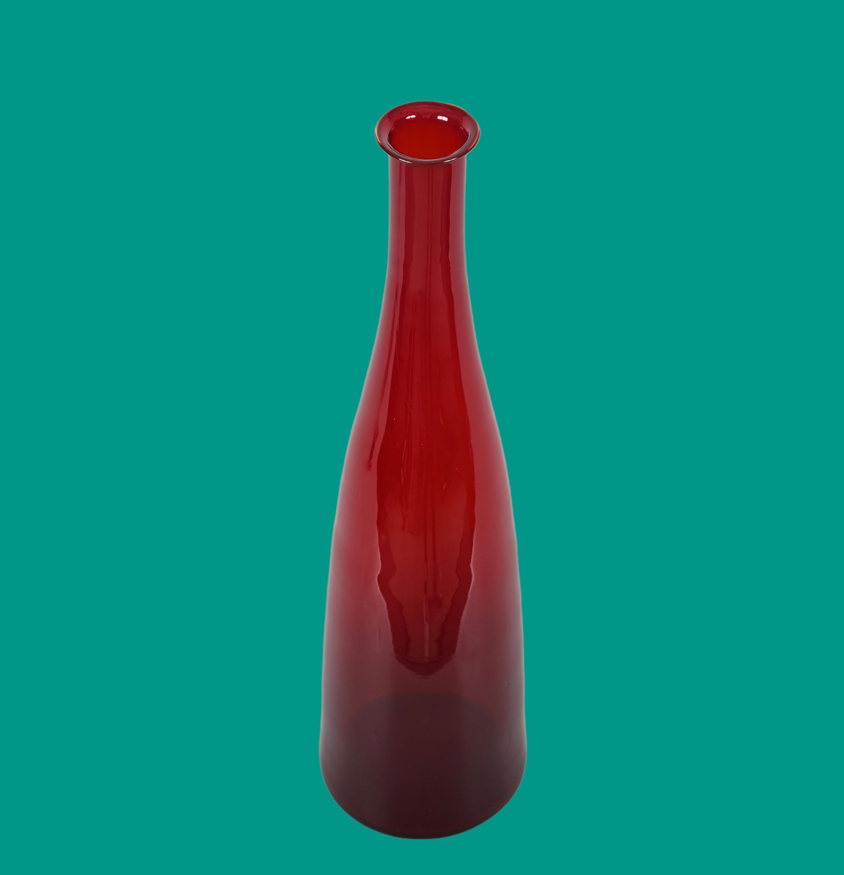 Mid-Century Modern smoked ruby red Murano blown glass bottle. This fantastic piece was designed in Italy during the 1970s.

This piece is outstanding thanks to the material, a breathtaking ruby red Murano glass, that has the effect of getting