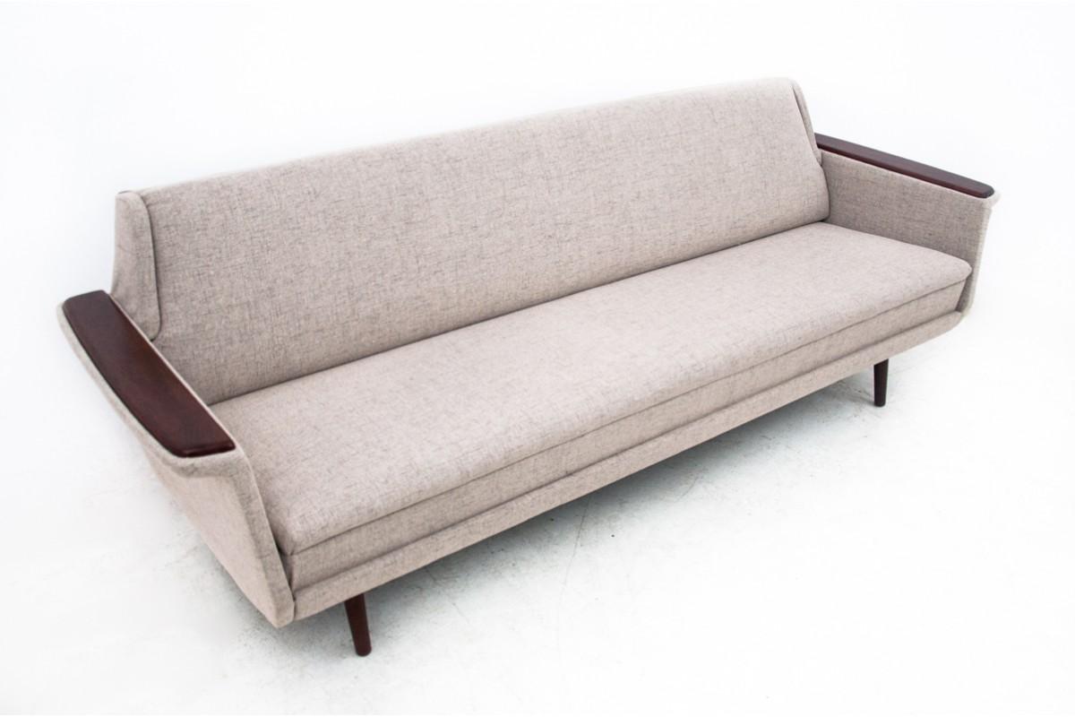 Three seater sofa that can be unfolded into bed. 
Sofa is from the 1960s, made in Denmark.
The sofa has been covered with a new fabric.
Wooden armrests insters made od walnut wood (restored)
In excellent condition, ready to be put into interior.