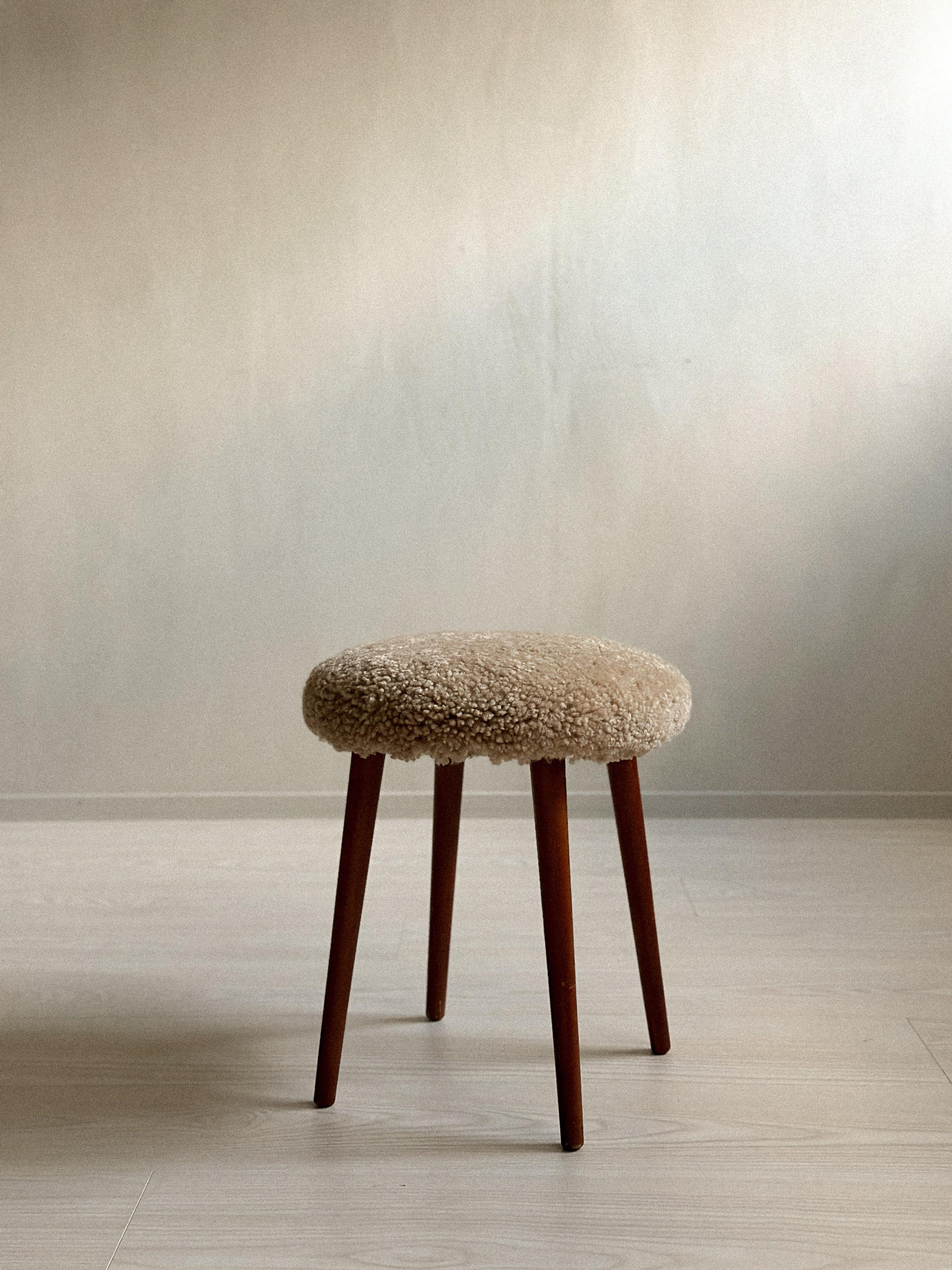 Un tabouret unique du milieu du siècle dernier, datant des années 1950, récemment retapissé en peau de mouton de première qualité. 