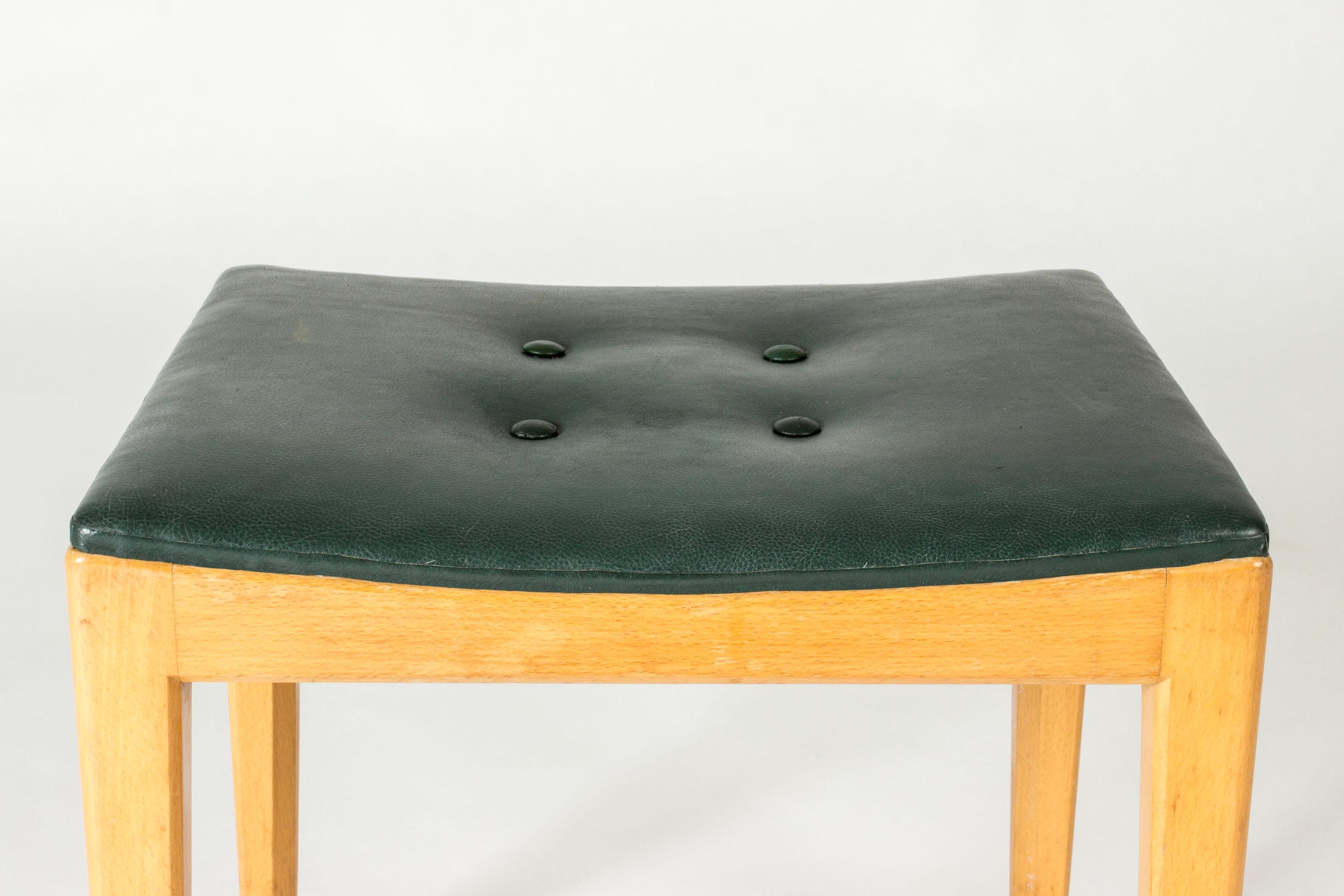 Sgabello di Axel Larsson dal design pulito. Realizzata in betulla con gambe leggermente affusolate, seduta rivestita in pelle verde scuro.