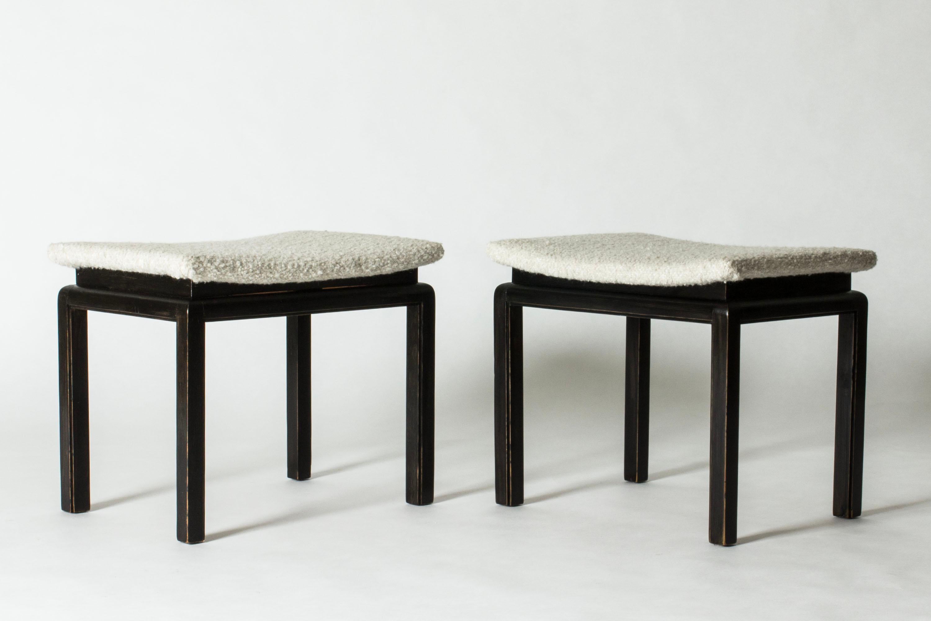 Pair of elegant Danish Modern stools from Lysberg, Hansen & Therp, in a clean form with seats with a slight curve. Made from black lacquered wood, seats upholstered with bouclé fabric.