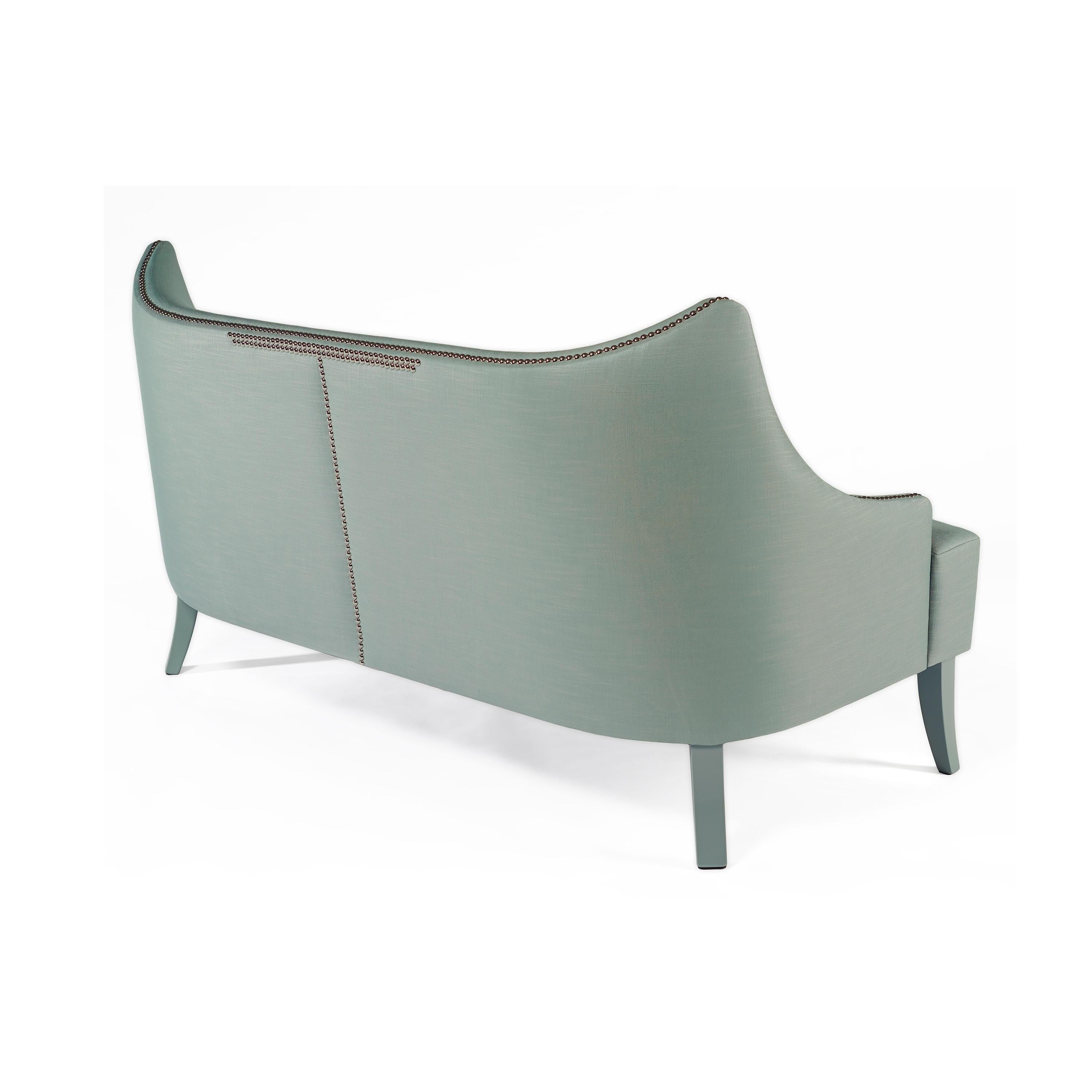 Ce canapé est l'exemple même d'un design qui incite à la sérénité. Avec une silhouette enveloppante et une luxueuse assise profonde, ses courbes sensuelles et son dossier confortable s'adaptent parfaitement au corps. Les clous qui ornent les courbes