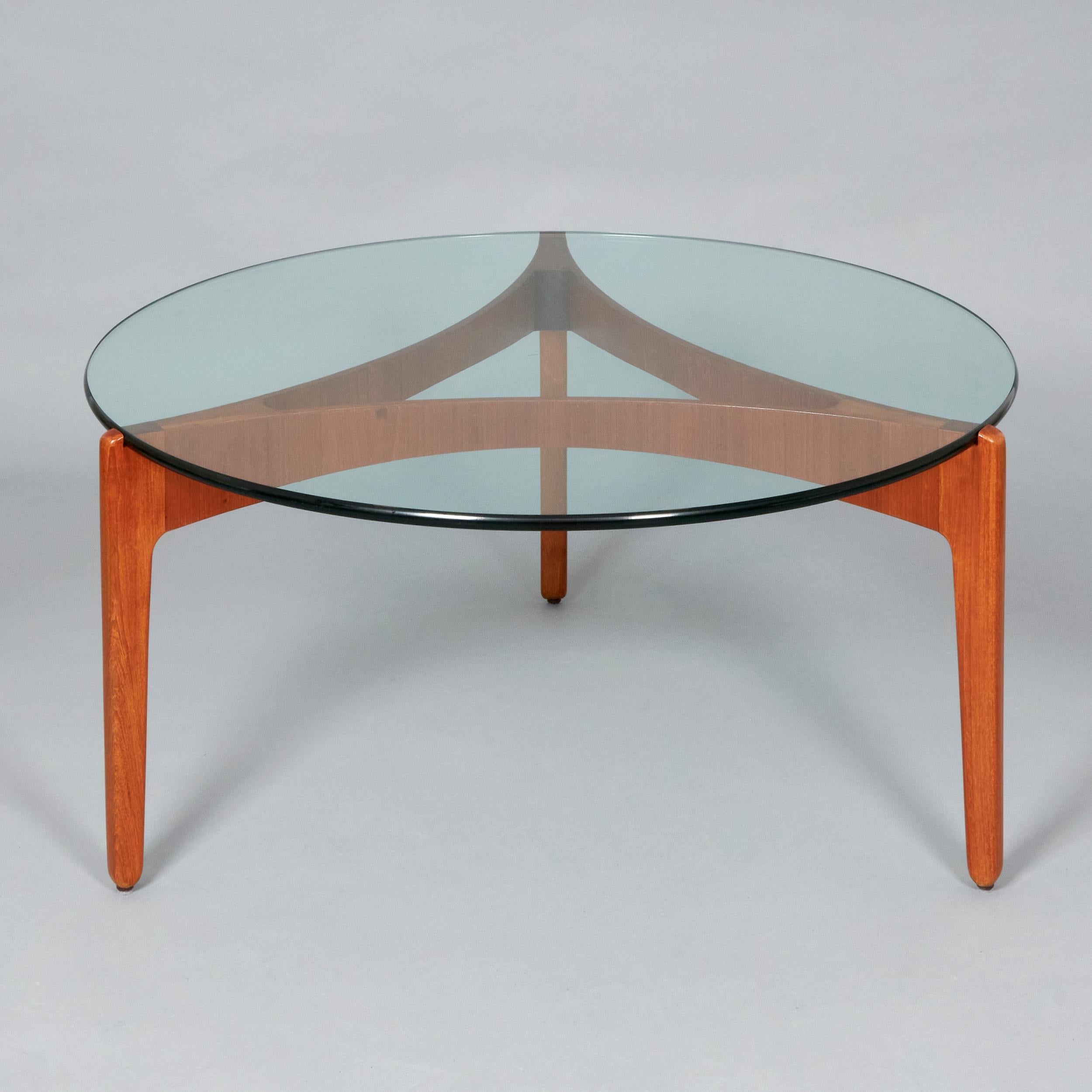 Round Coffee table in glass and Teak Plywood designed by Sven Ellekaer for Christian Linnebergs Møbelfabrik. Denmark, 1960s.
Excellent vintage condition, the wood is refinished though it may present unique traces of use and time. 

Bent plywood was