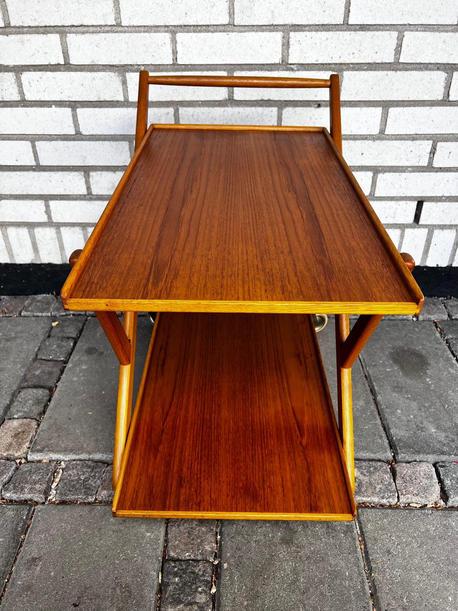 This is a rare Swedish mid century serving trolley by Yngvar Sandström for AB Nybrofabrikerna, Nybro. The Trolley is made in teak and oak and is easy to fold for easy storage according to the pictures. 

The trolley is in very good condition and