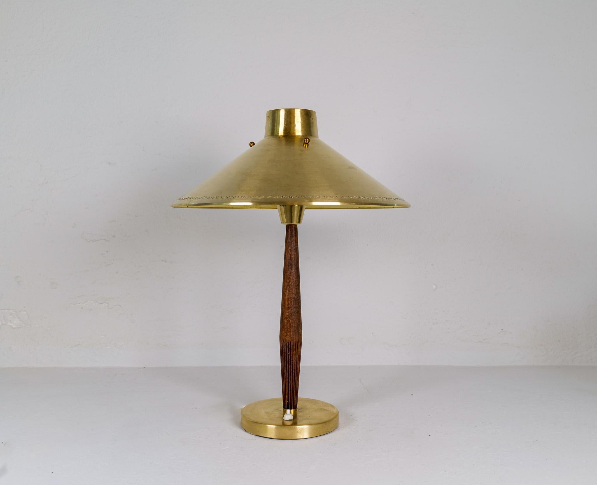 Elegant Swedish table lamp made in 1940 for ASEA and designed by Hans Bergström. A metal and brass base with beech leading up to a patinated brass shade in a nice combination. 

Good condition with some wear consistent with age and use, the brass