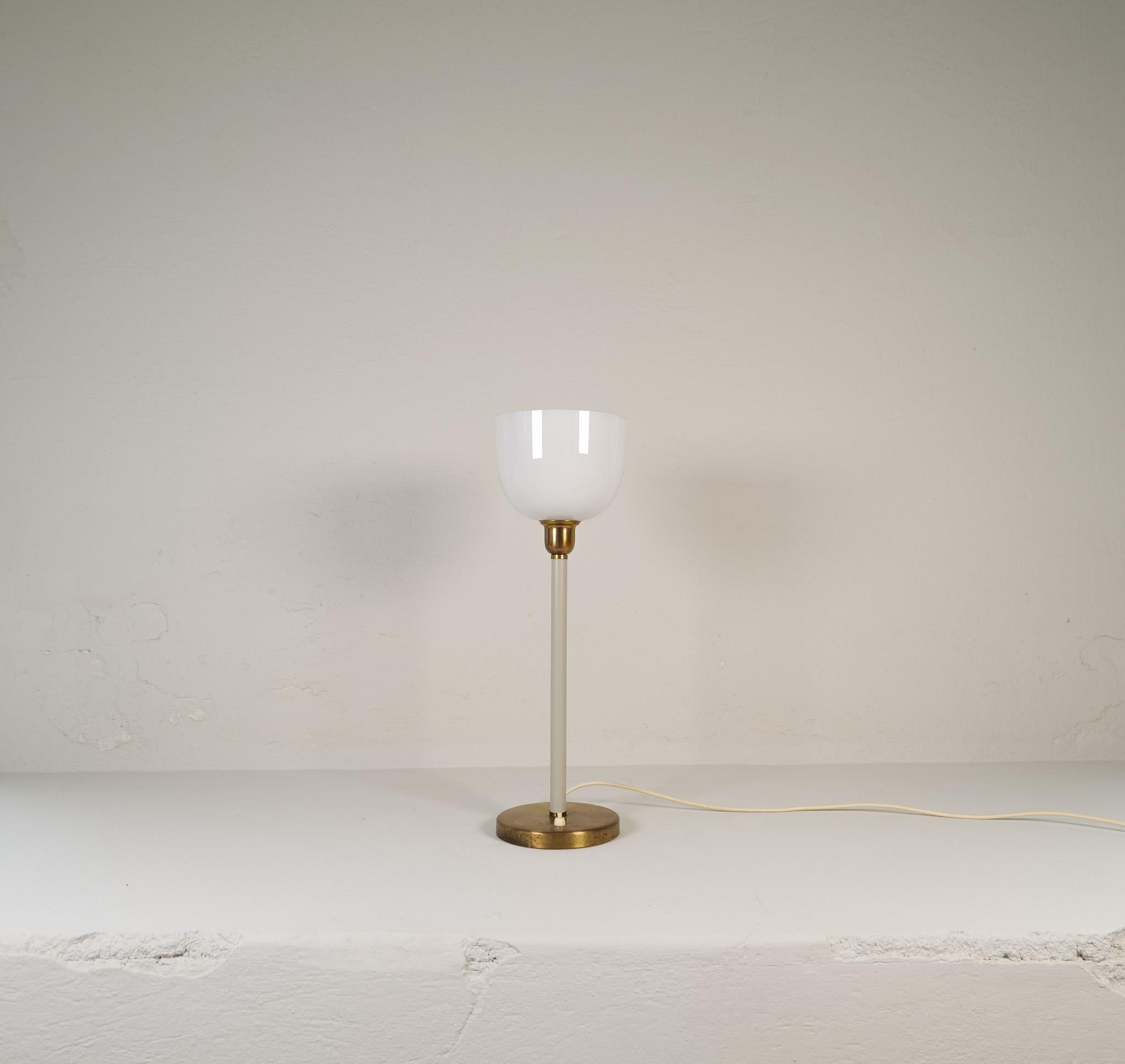Genuinely nice Swedish table lamp made in the 1940s for ASEA and designed by Hans Bergström. With a brass base and a hard plastic rod leading up to an opaline glass. 

Good vintage condition with some wear consistent with age and use, base with