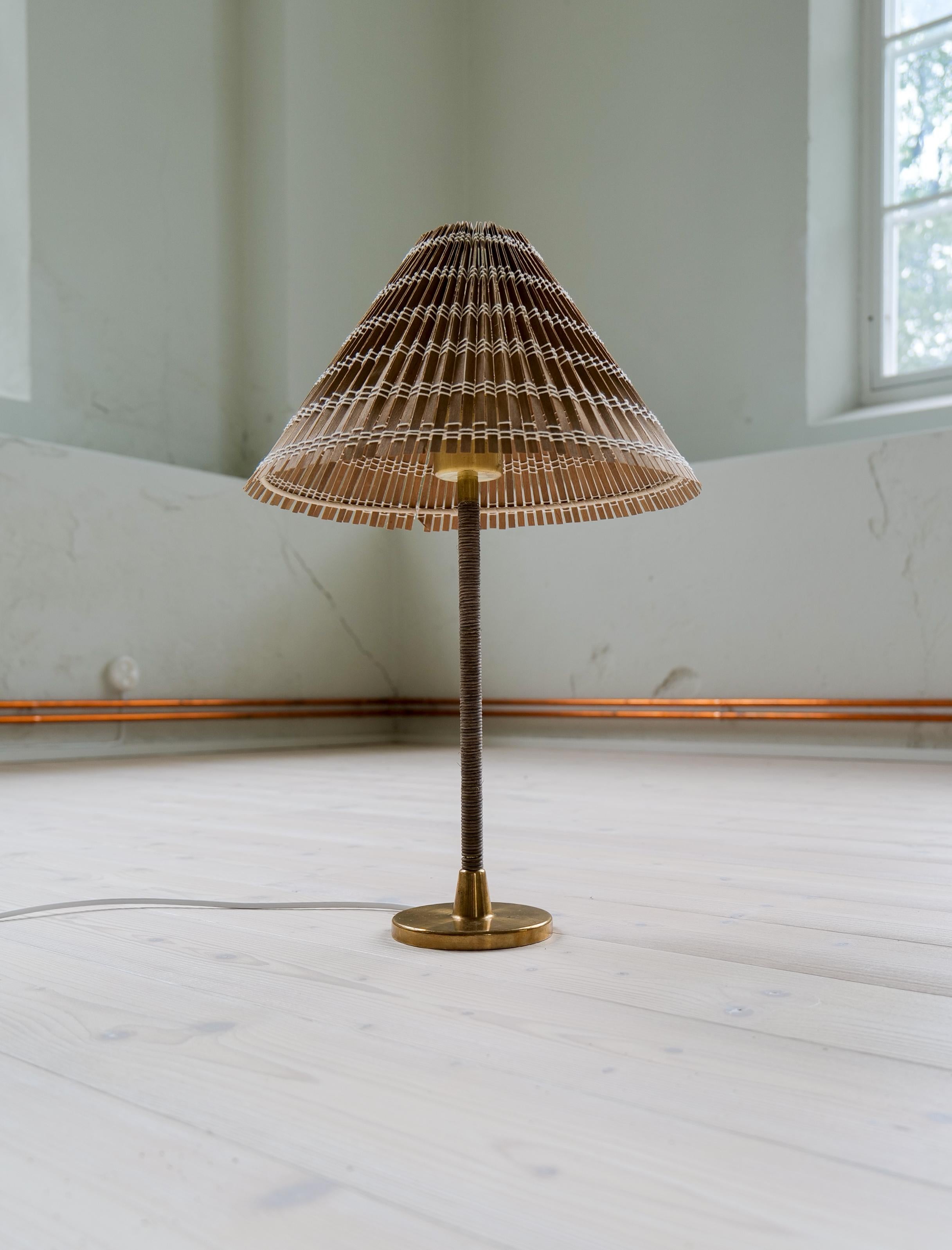 Cette lampe aux formes iconiques du design Design/One. Fabriqué en laiton avec cordon enroulé et abat-jour en rotin. La lampe donne un aspect exclusif et sophistiqué. 

Bon état Vintage, avec usure et petites taches sur la partie en laiton.