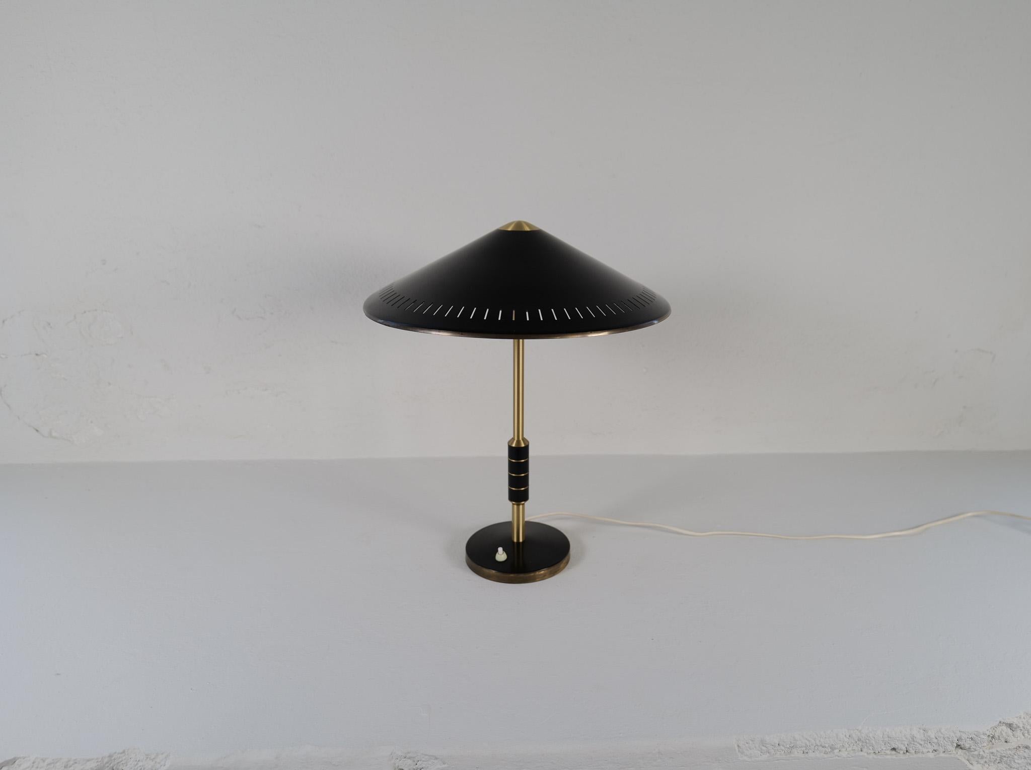 Midcentury Danish brass table lamp from Lyfa, designed by Bent Karlby 1956 Denmark. 
This somewhat rare black modell B146 with solid brass and two-light sources, stem decorated with black metal banding.

Good vintage condition, with wear and small
