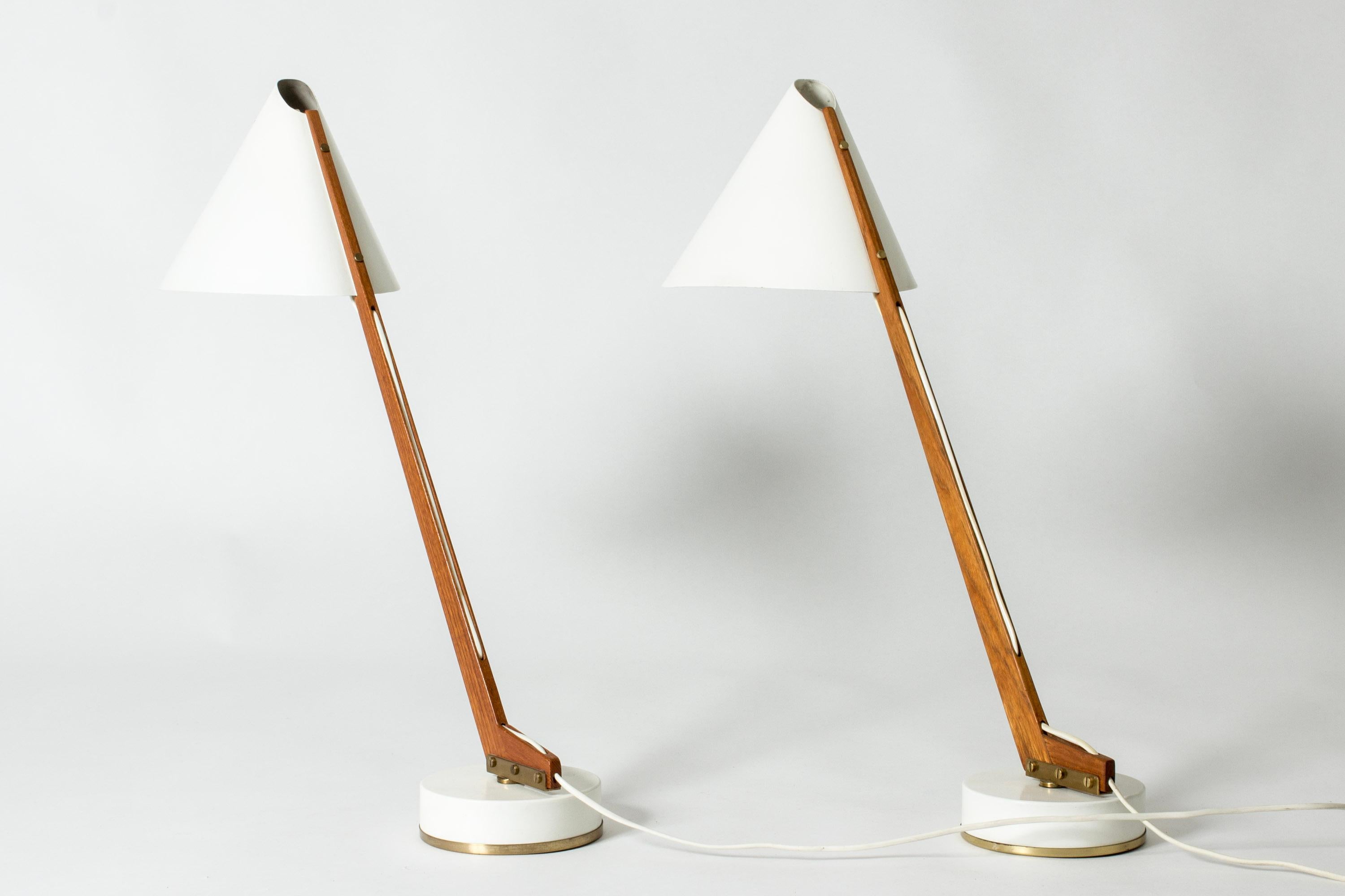 Pair of striking desk lamps by Hans-Agne Jakobsson, with teak stems and lacquered white shades and bases. Decorative brass details.