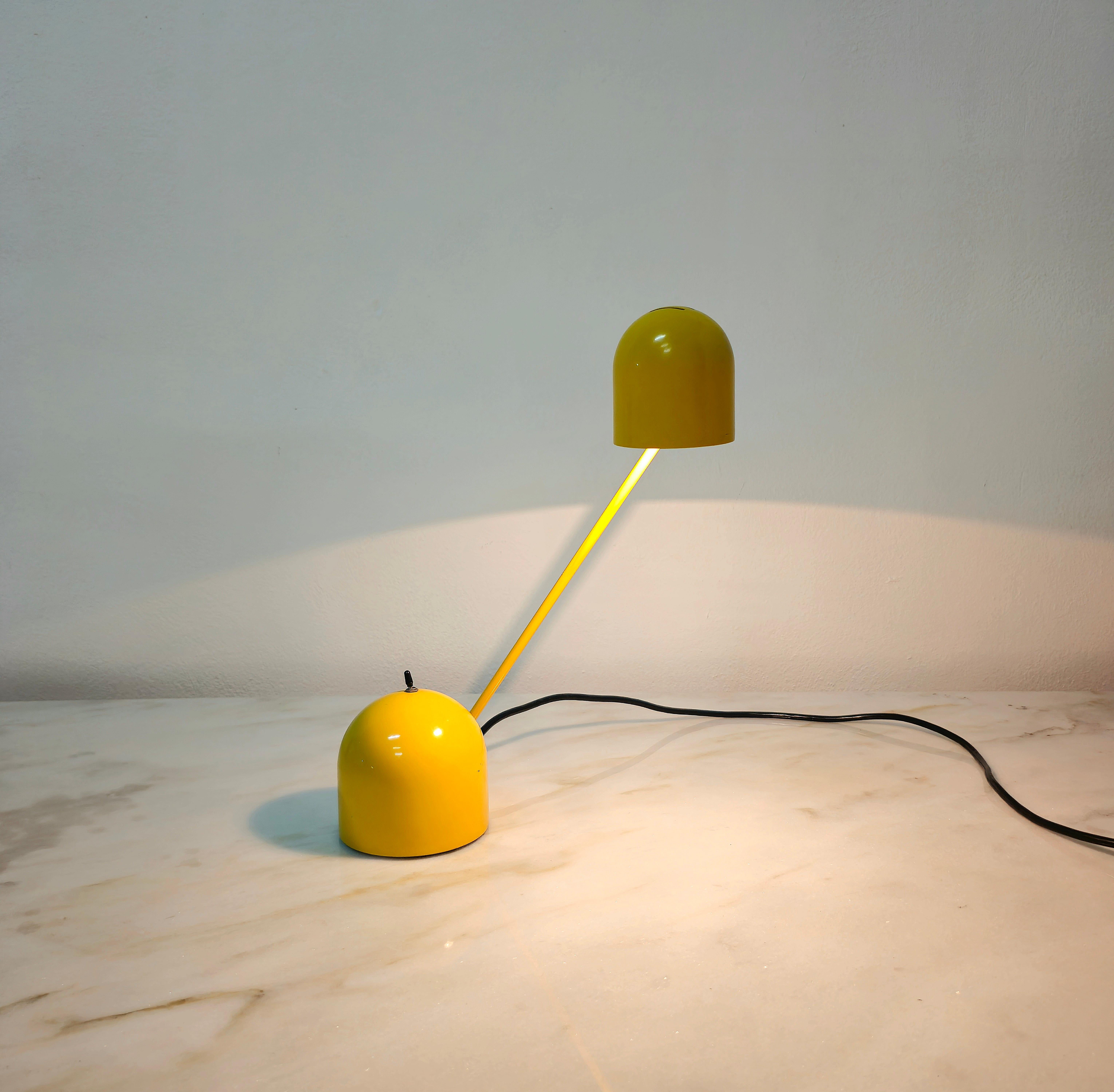 Table lamp made of metal and yellow enamelled aluminium. The particularity of this lamp is given by its multifunctionality, as both the arm and the diffuser can be directed, and thanks to the switch it is possible to decrease and increase the