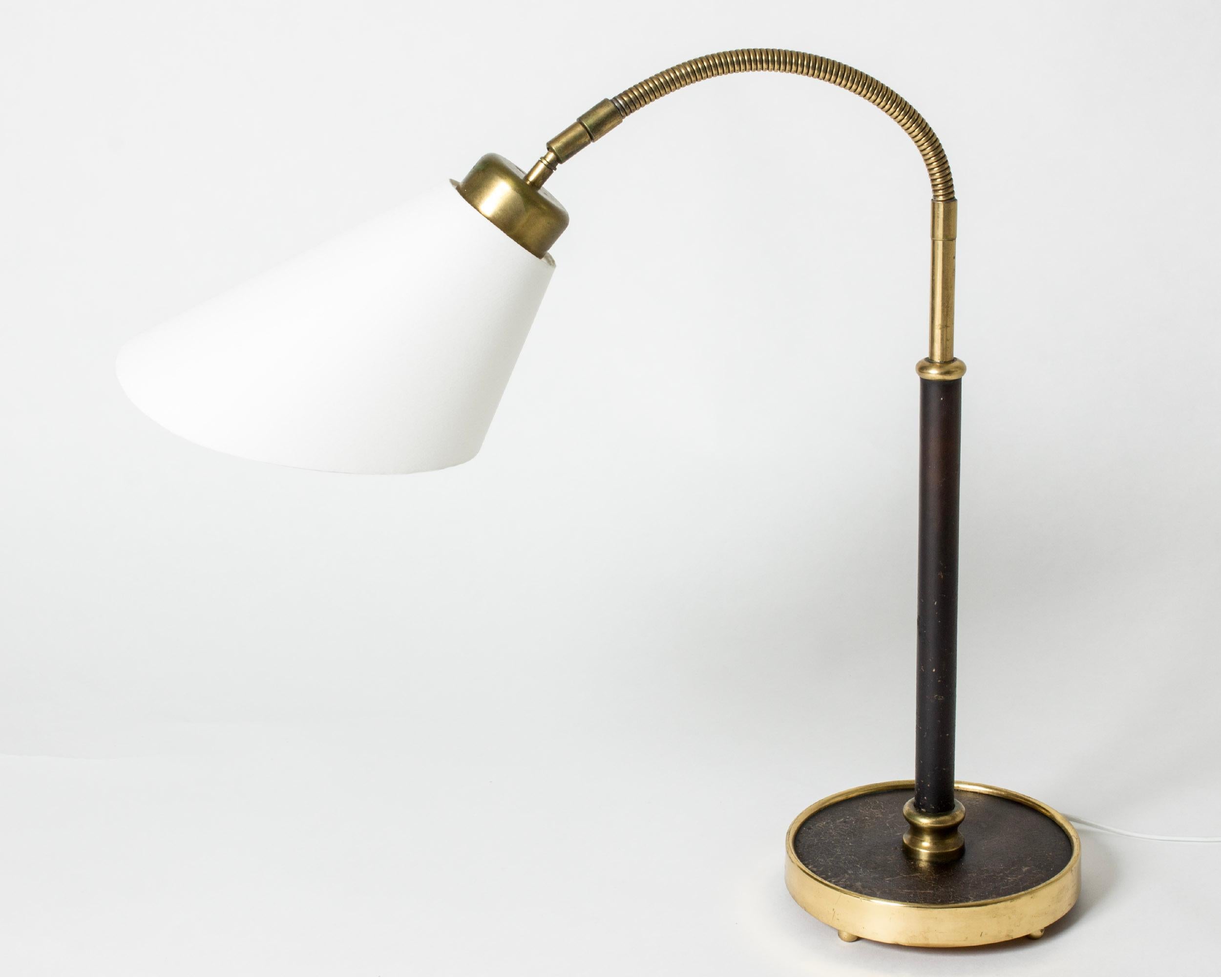 Rare, elegant brass table or desk lamp by Josef Frank, with original leather upholstery with some patina on the stem and base. Flexible neck and decorative round brass feet.