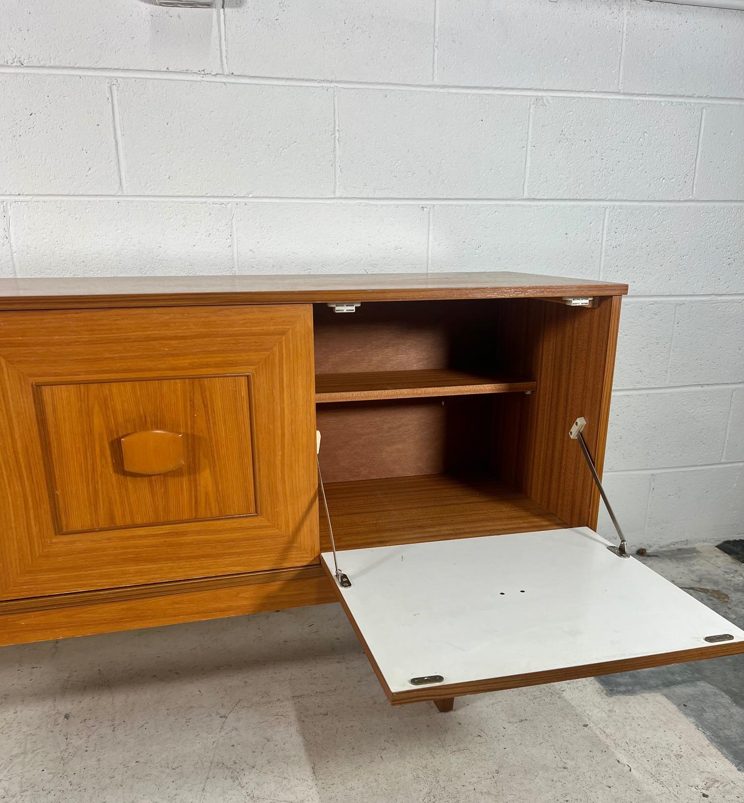 Outstanding teak credenza by Stonehill. Model Stateroom. Featuring 3 drawers on the left, drop down door bar on the right and a cabinet with removable shelves in the middle.
Very good condition. Minor marks on the top. A chip on the left top corner