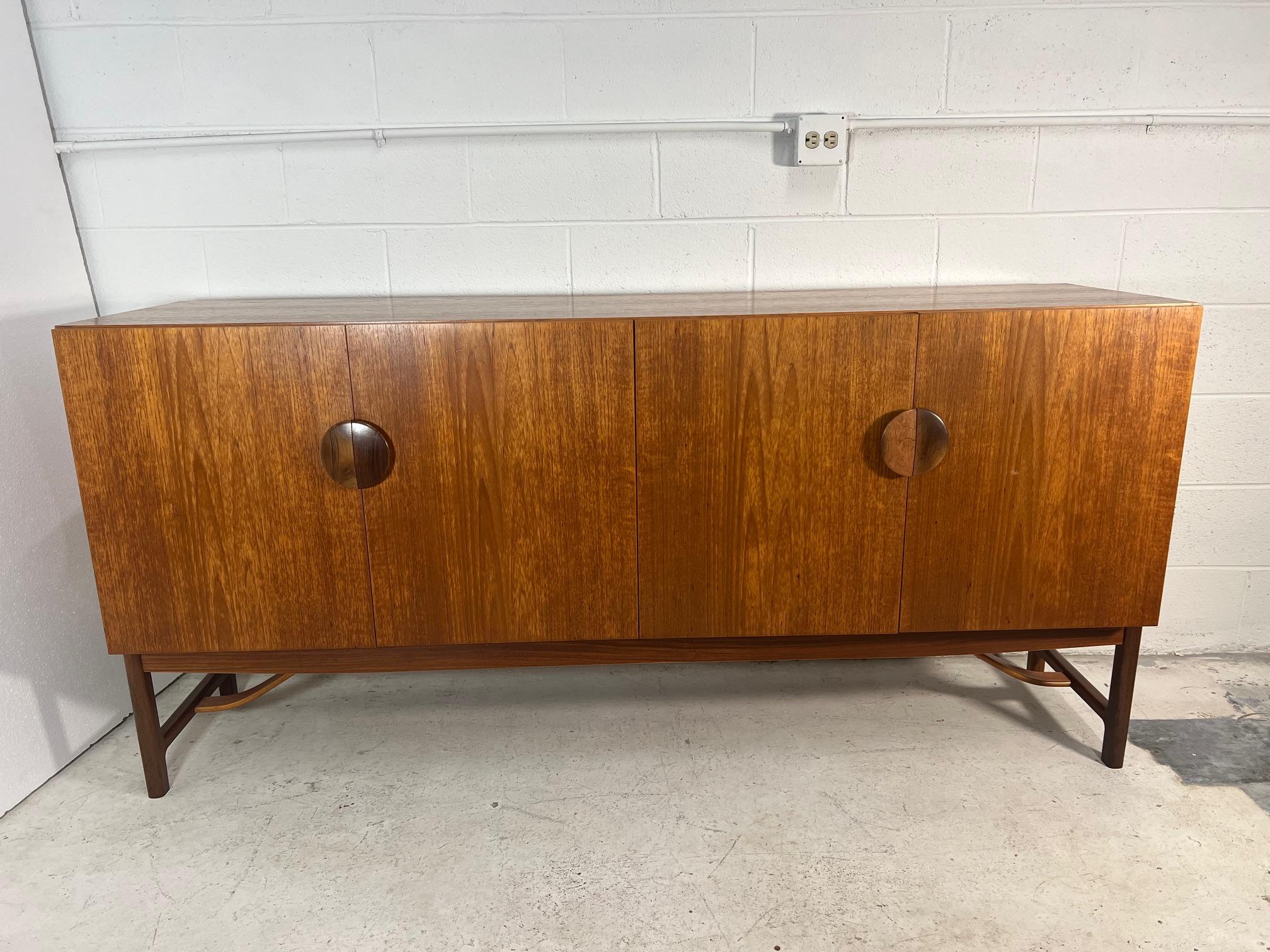 Stunning mid century teak credenza designed by renowned Danish designer Ib Kofod Larsen for G Plan. Designed in the 60s as part of the 'Danish Design Dining Group'. It comes with Bombay rosewood split handles.

Lots of storage room inside. An