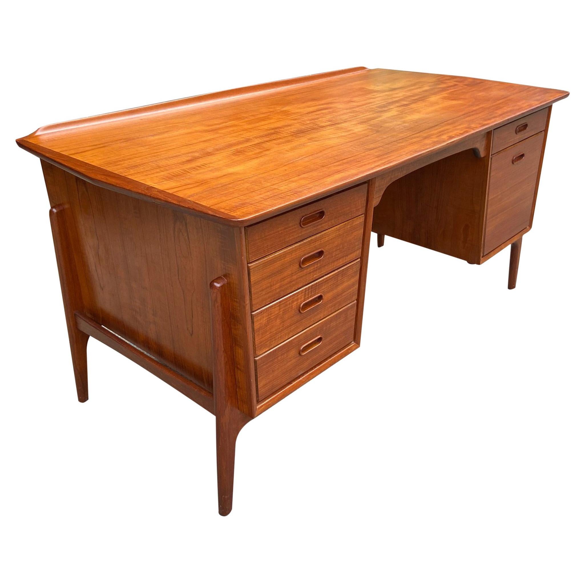 For your consideration is this gorgeous teak desk designed by Svend Aage Madsen. Featuring six drawers including a hanging file cabinet. Top desk surface has a raised edge. The back of the desk is finished with a shelf for additional storage all